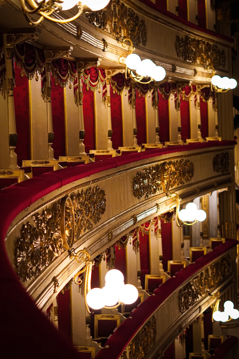 Red velvet theatre balconies with carved gold ornament. Architectural inspiration, not a Hegemon Jang venue.