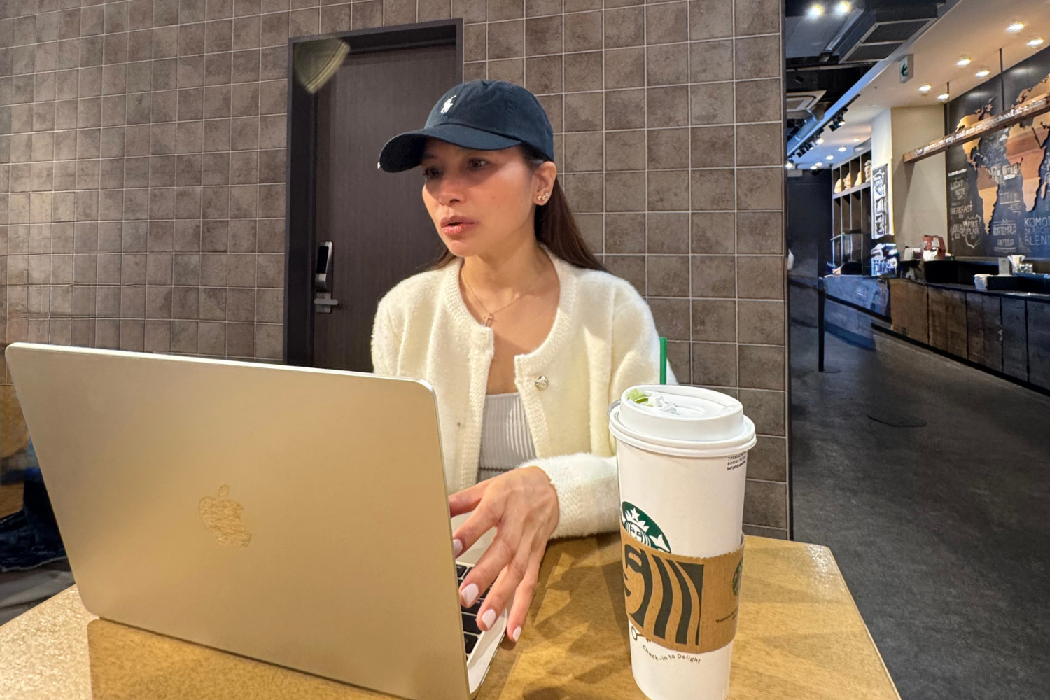 Freelancer working on laptop at Starbucks Dotonbori in Osaka before continuing travel itinerary.