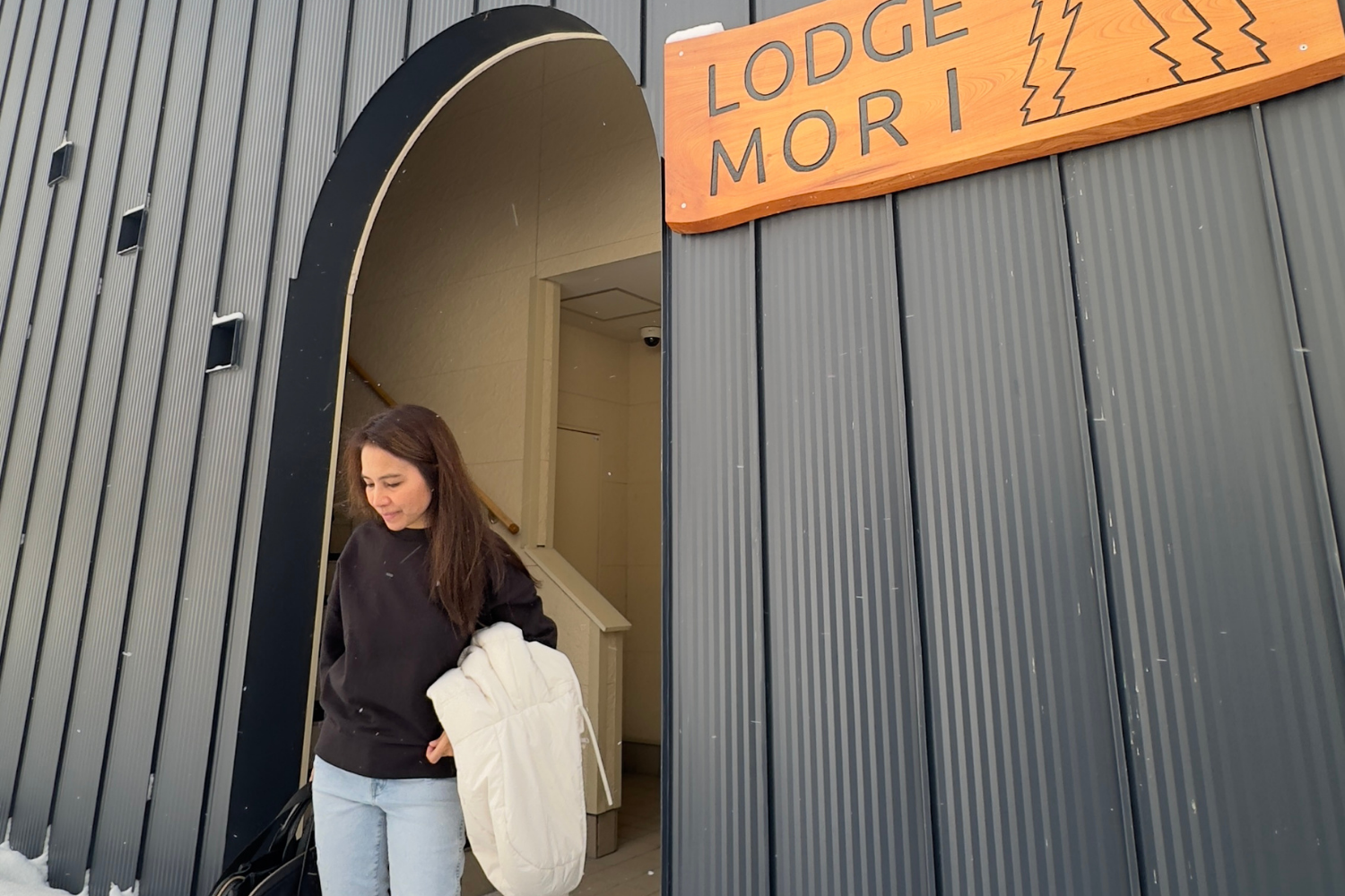 Traveler in Niseko standing outside after checking out from luxury Airbnb.