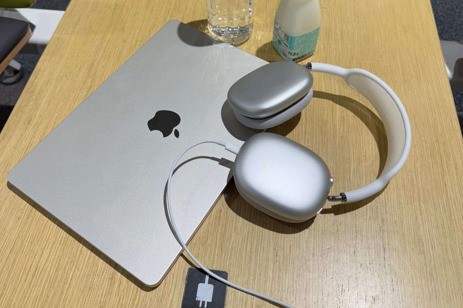 Laptop and AirPods Max on a desk at Kansai Airport, prepping for the next remote meeting while in transit.