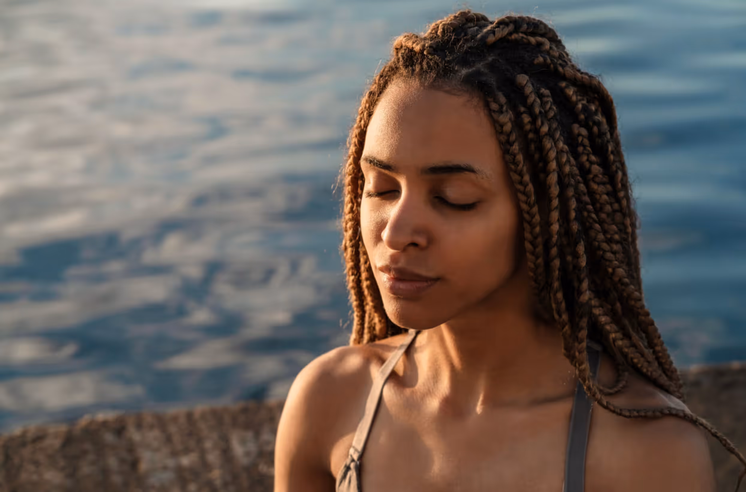 Woman by the ocean in golden sunlight