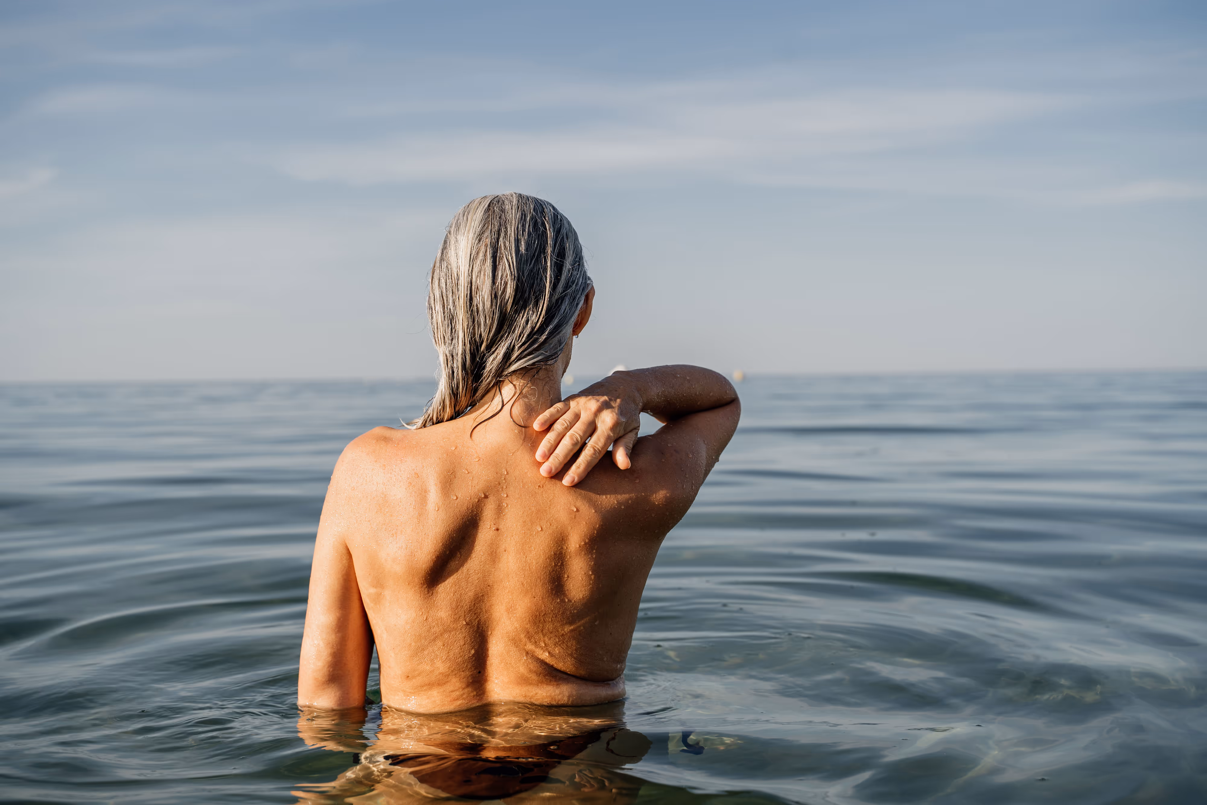 Woman standing in calm ocean water