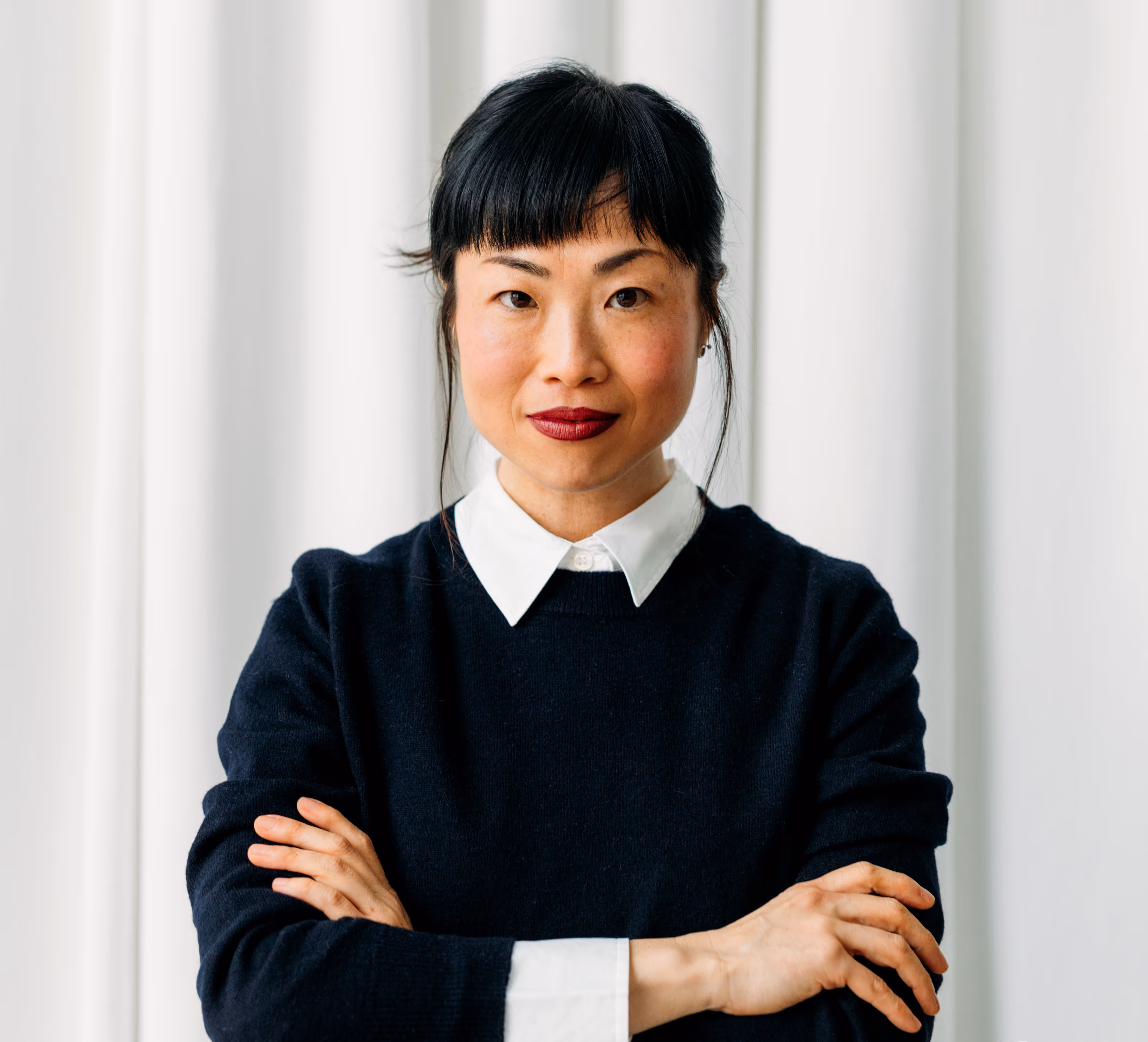 Professional woman with black hair, arms crossed