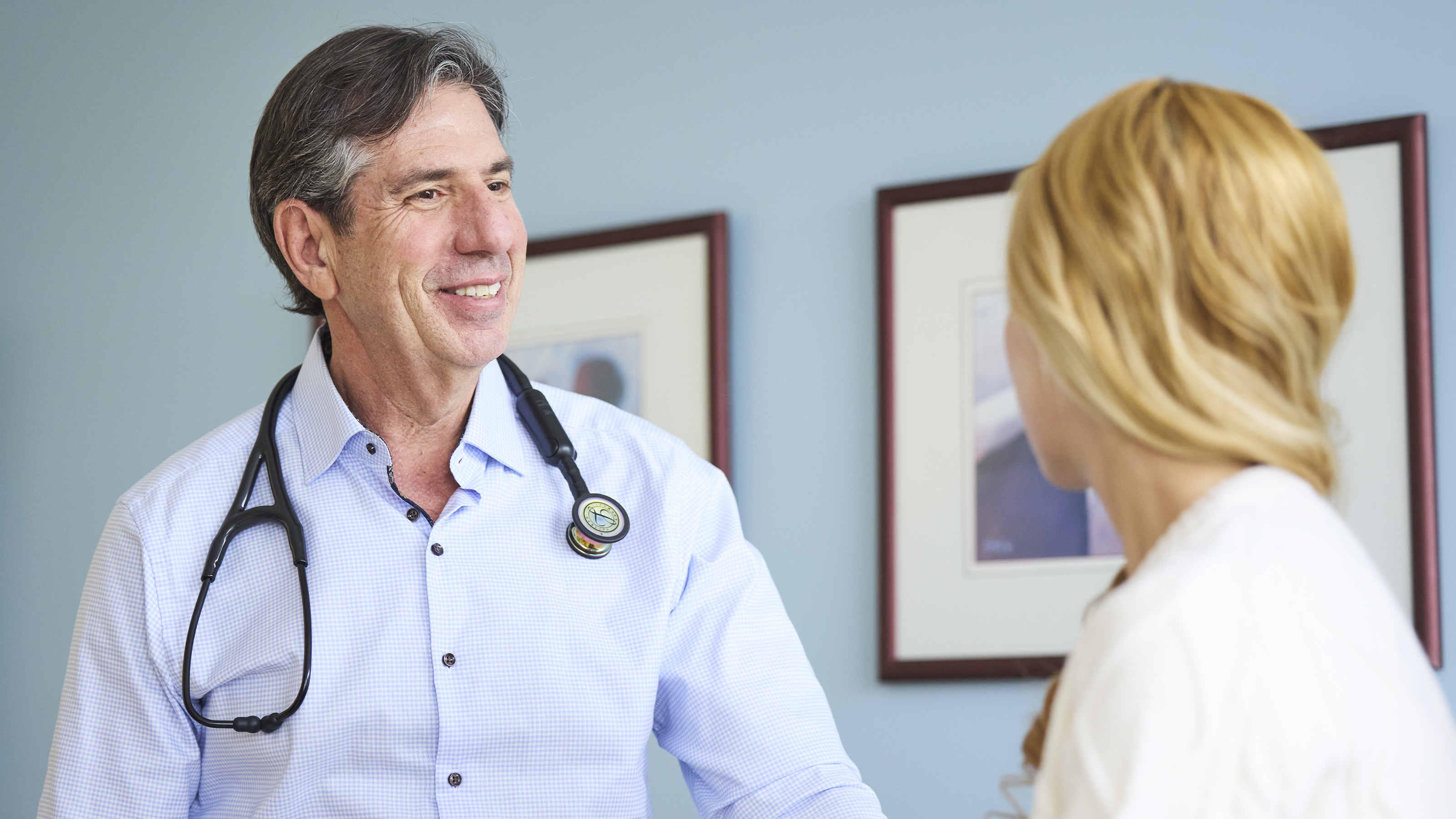Doctor consulting with patient during medical appointment in exam room.