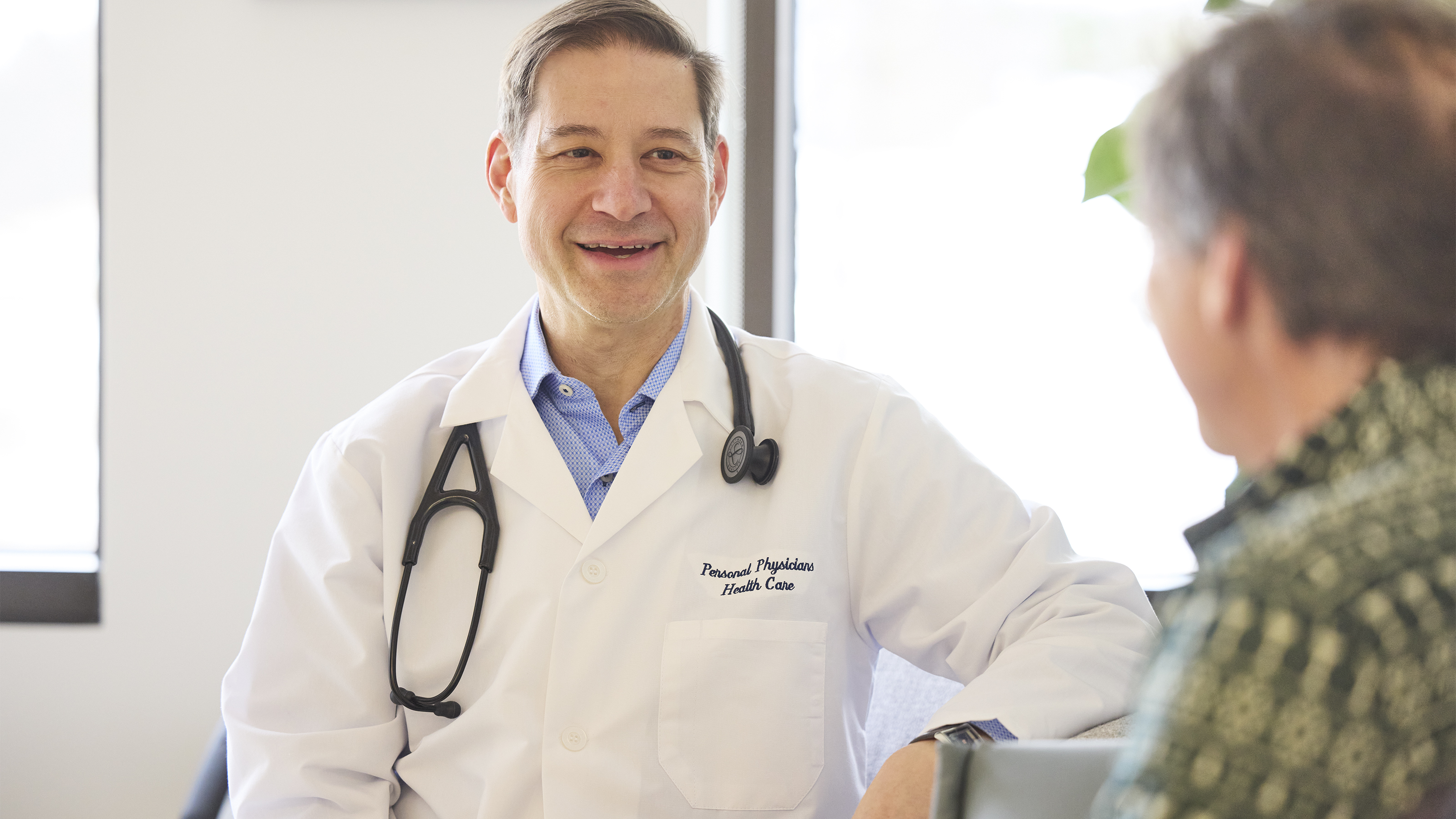 Doctor reviewing information on a tablet with a patient during a consultation.