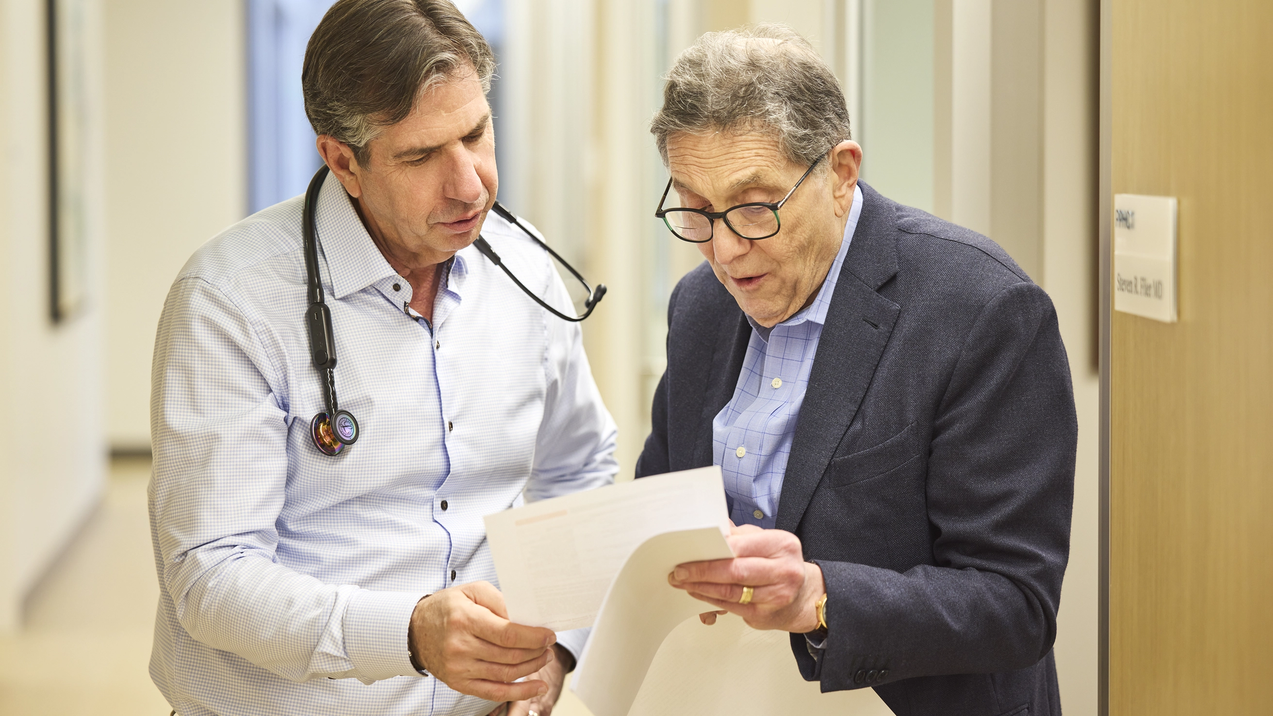 Doctor reviewing medical form with patient during consultation.