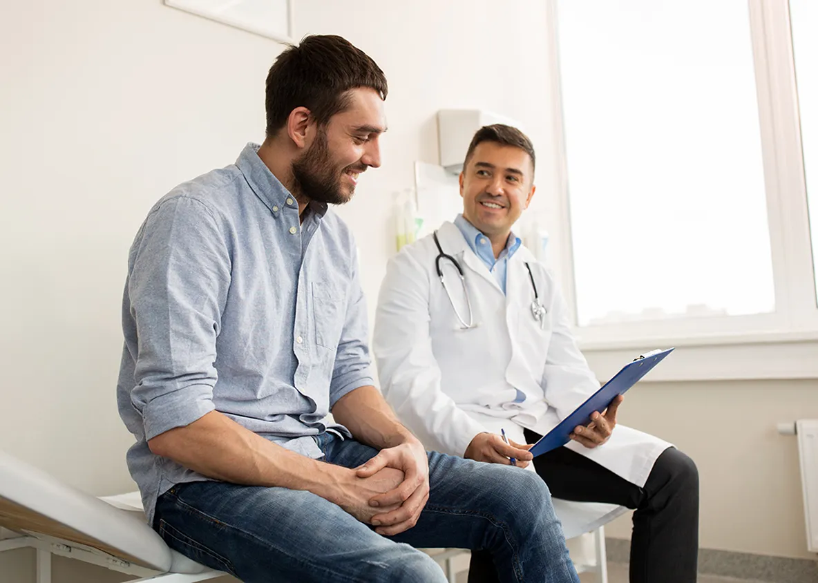 Doctor talking with male patient during office visit.
