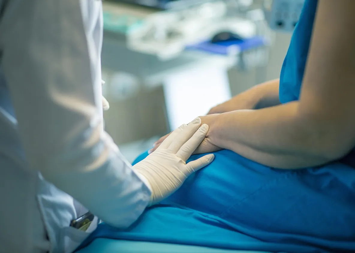 Physician comforting patient with supportive hand during care.