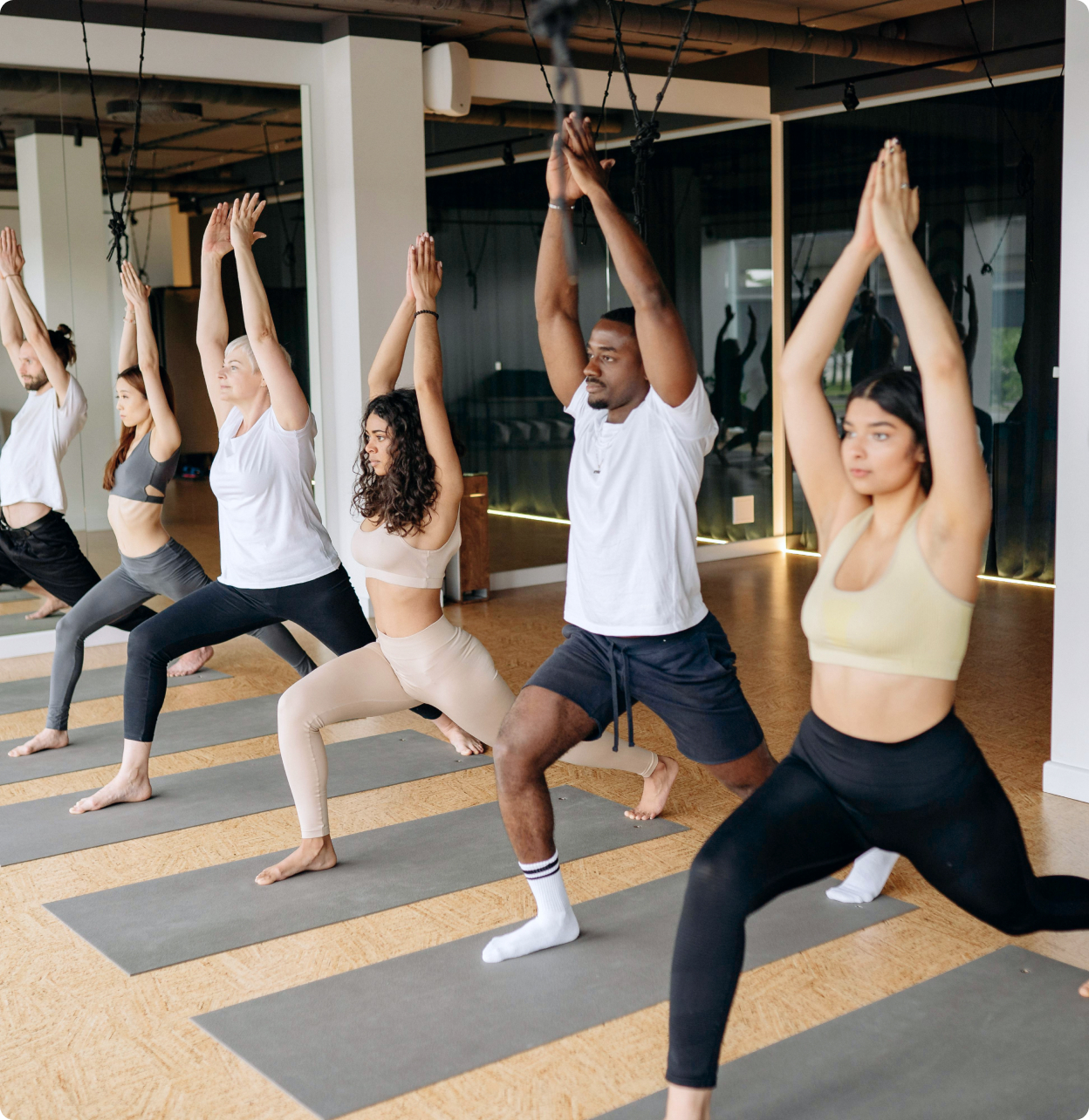 Group fitness class practicing guided yoga in studio.
