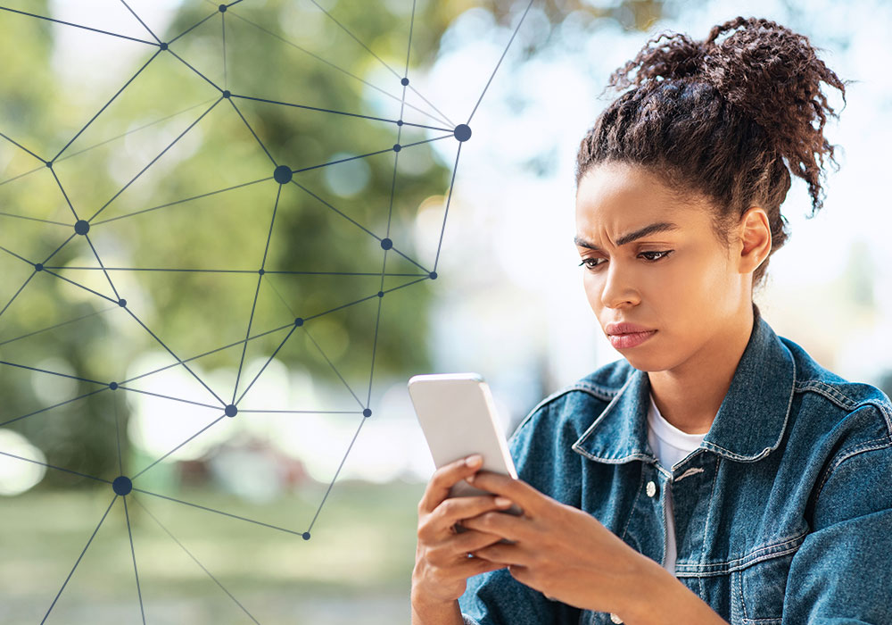 Woman looking concerned while checking phone with network connections overlay, representing phone scams and fraud