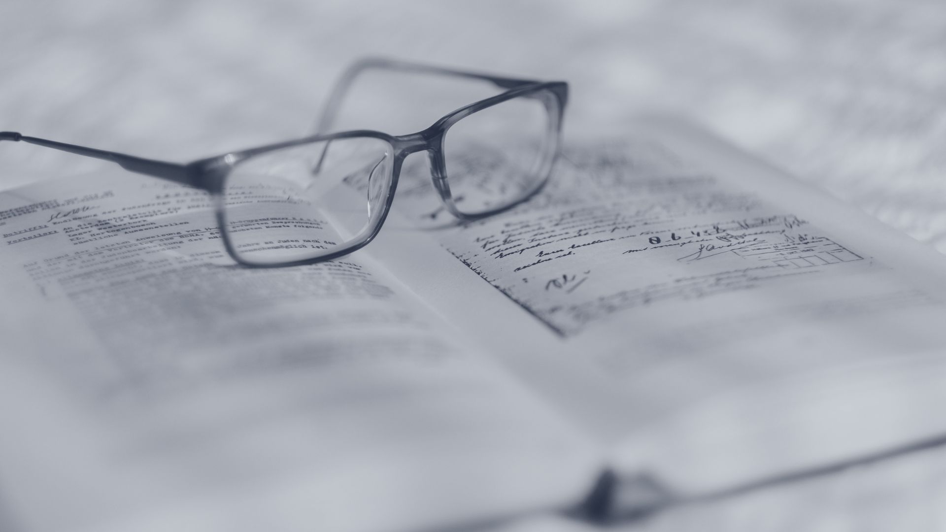 Reading glasses on an open book for a legal due diligence guide