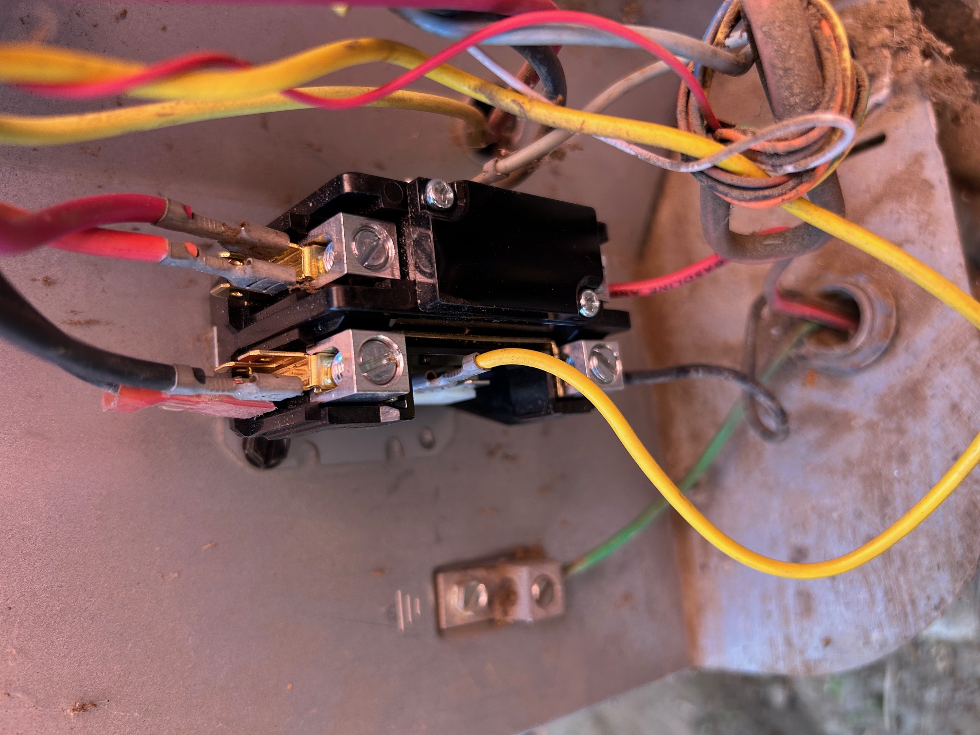 Close-up of electrical contactor with connected black, red, yellow, and green wires inside a metal enclosure.