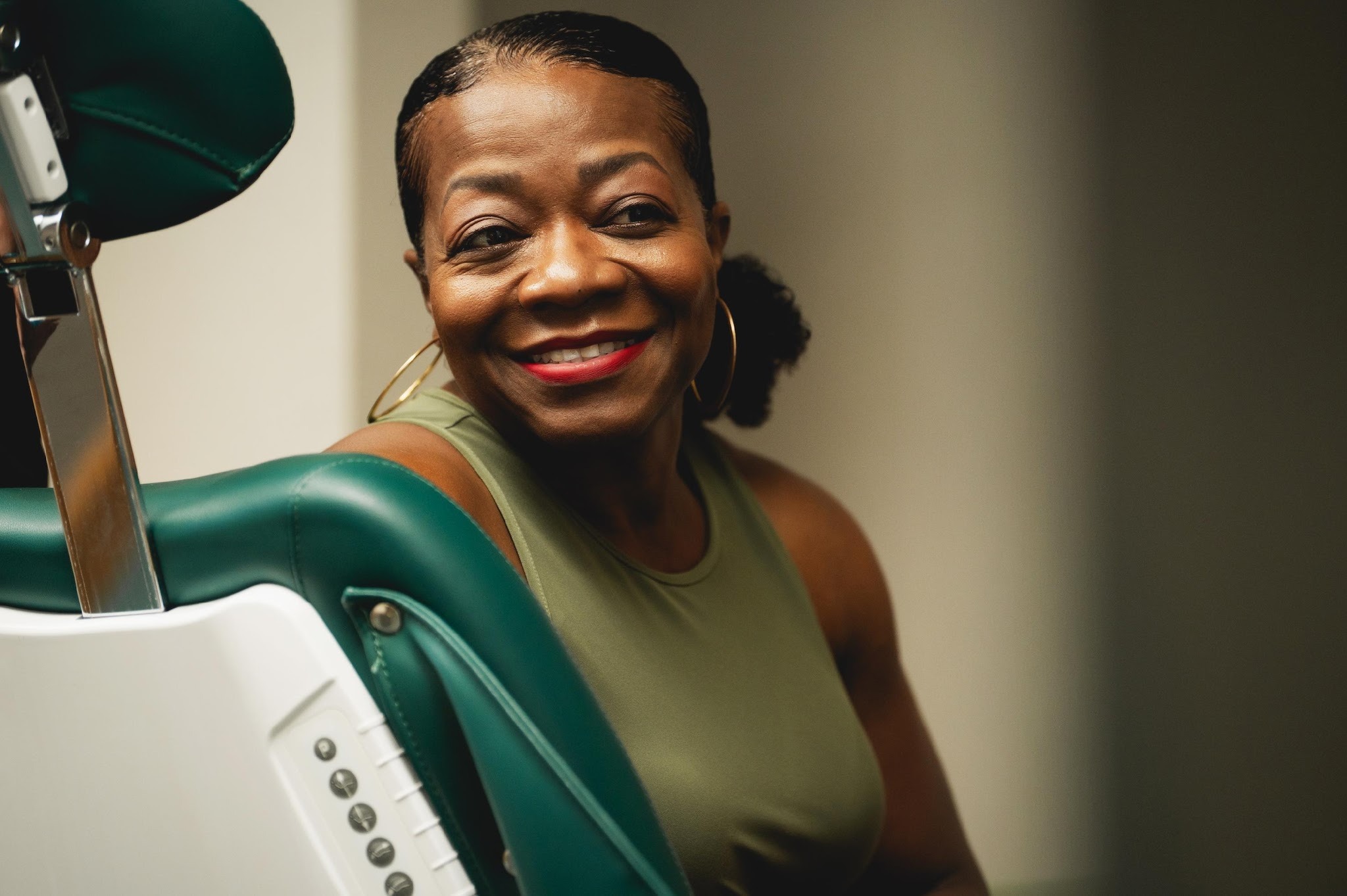 Patient smiling with dental professional holding treatment materials in clinical setting