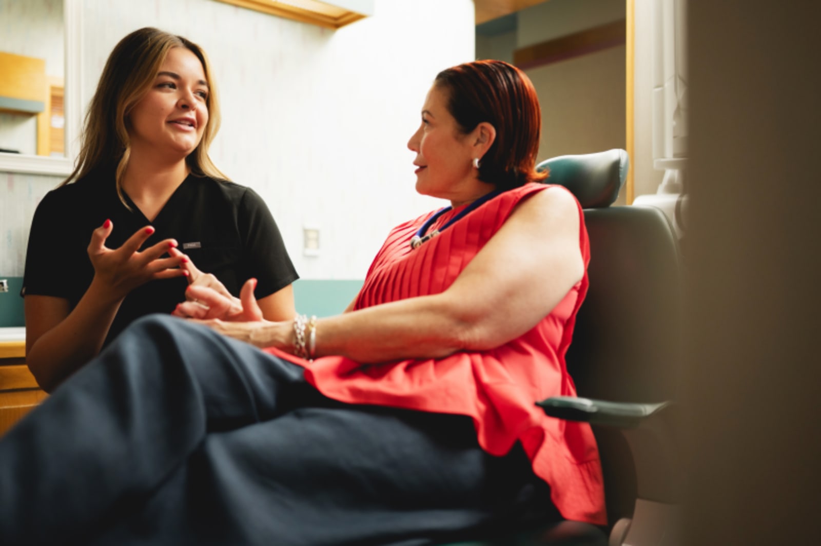 Female dentist in consultation with female patient discussing treatment options together