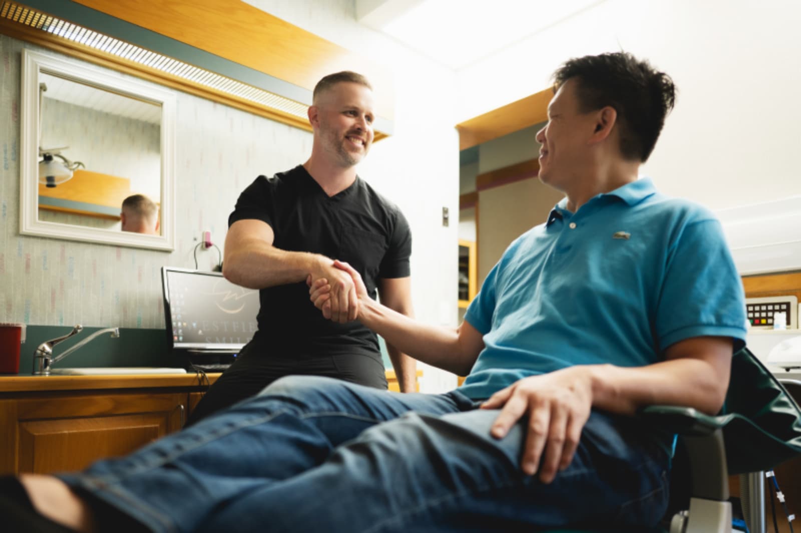 Dentist demonstrating dental implant procedure details to patient in treatment chair