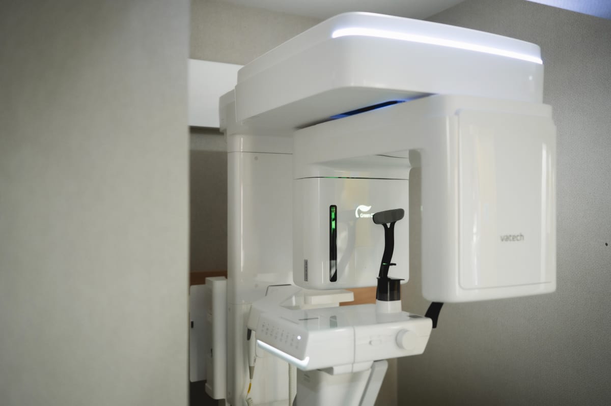 Modern dental office treatment room with white intraoral camera equipment mounted on wall