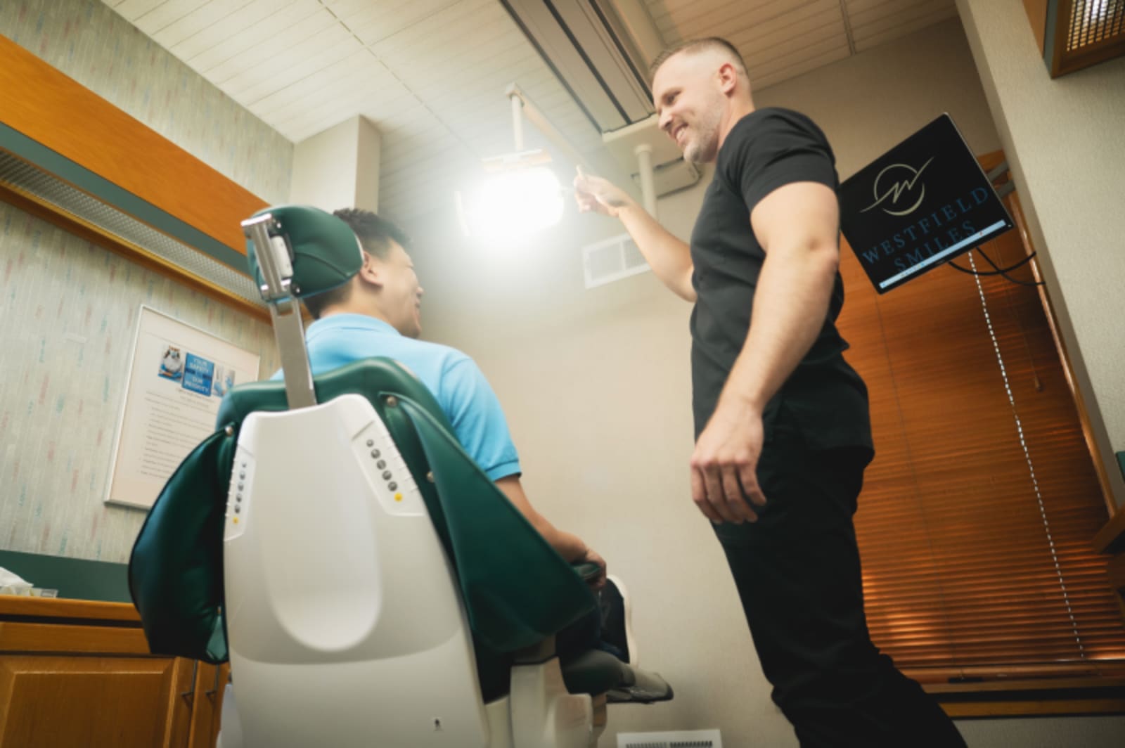 Dentist explaining dental treatment using intraoral camera to patient in clinical setting