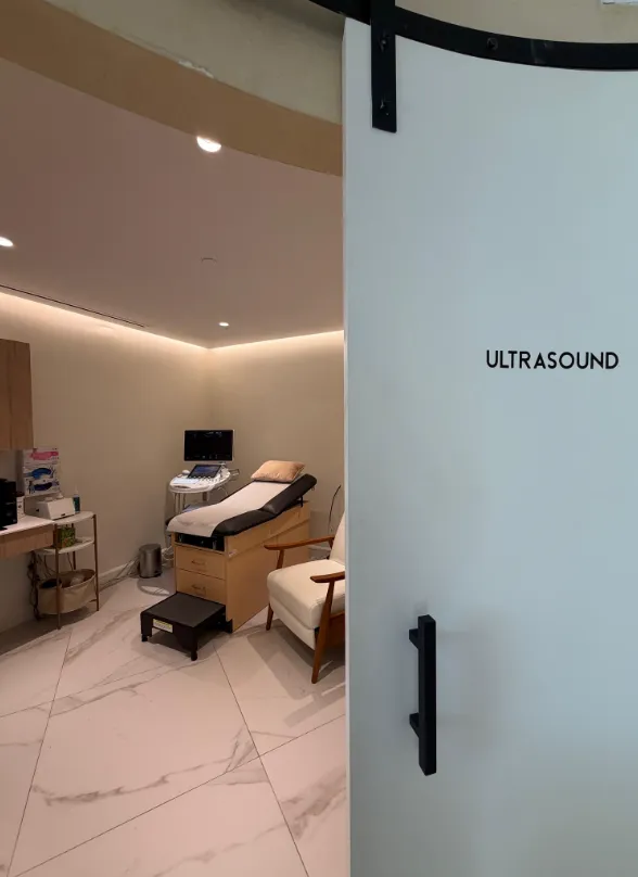 The ultrasound room at Materna's West Village office, seen past the frosted sliding door