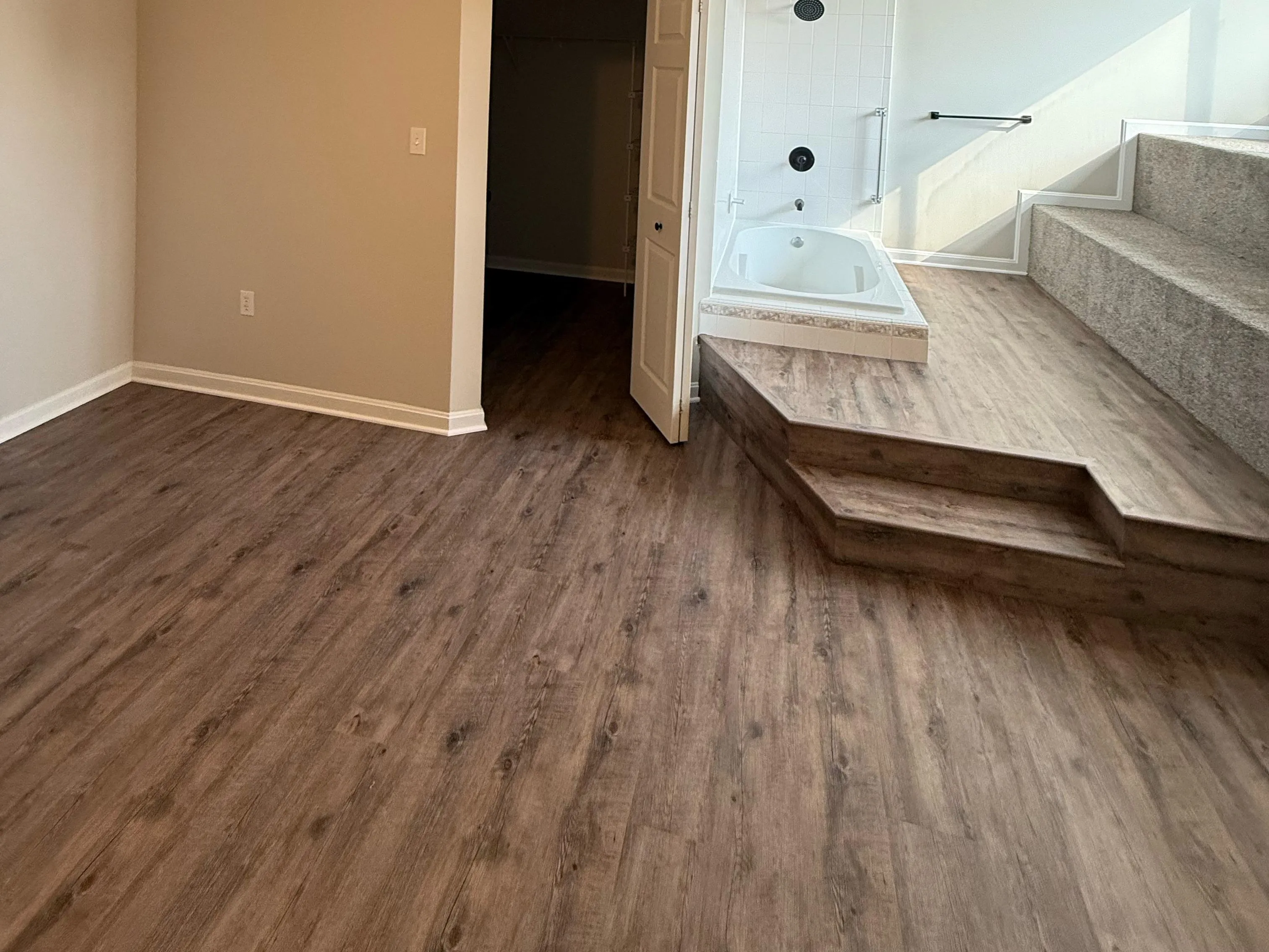 Room with luxury vinyl plank, baseboard, shoe molding, and transitions