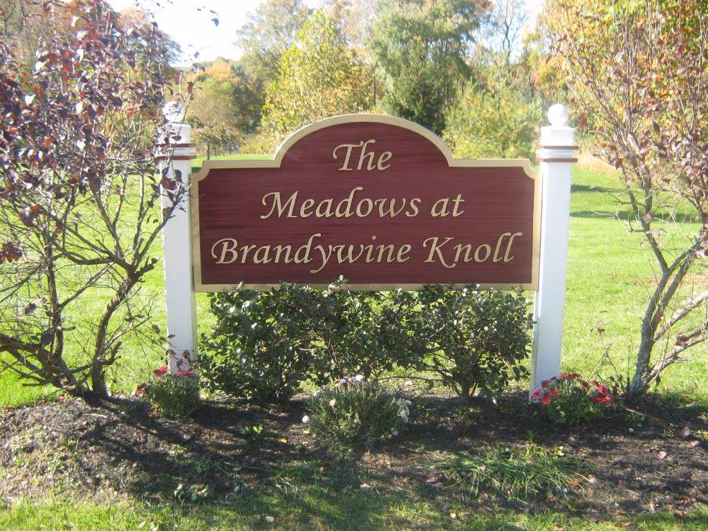 Carved HDU sign between two white posts with white ball finials