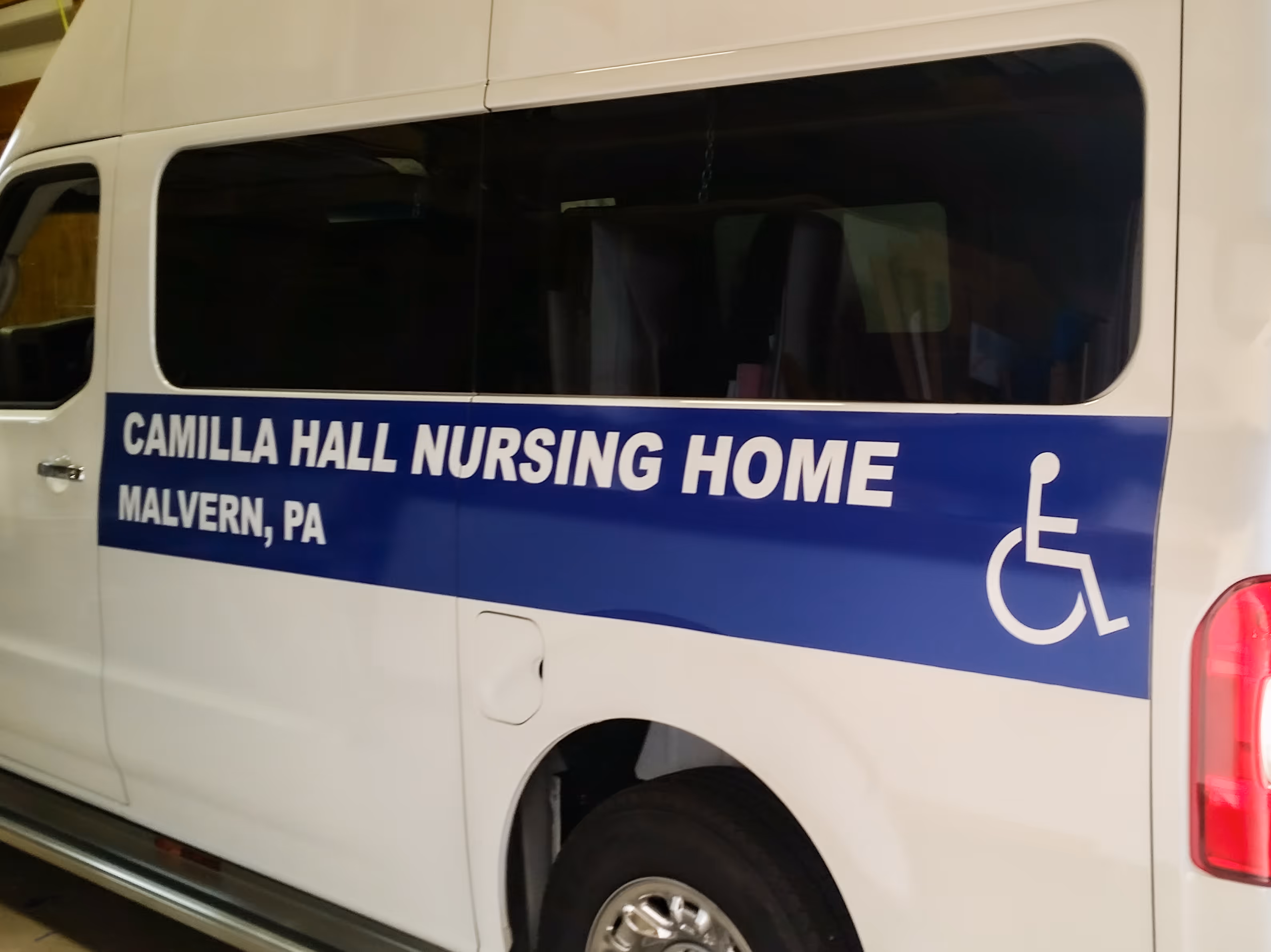 Blue vinyl handicap marking on a white passenger van