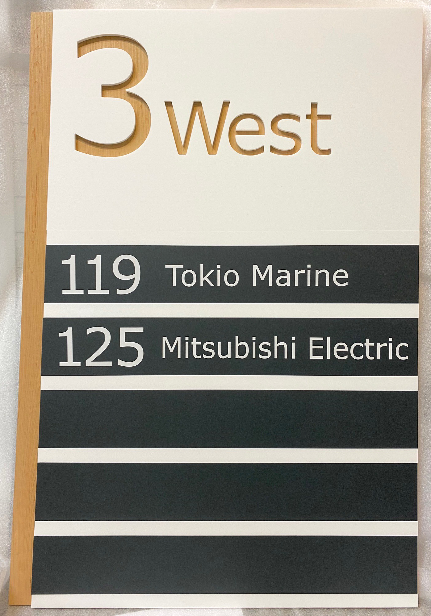 Custom wayfinding sign made of routed acrylic on a natural wood backer