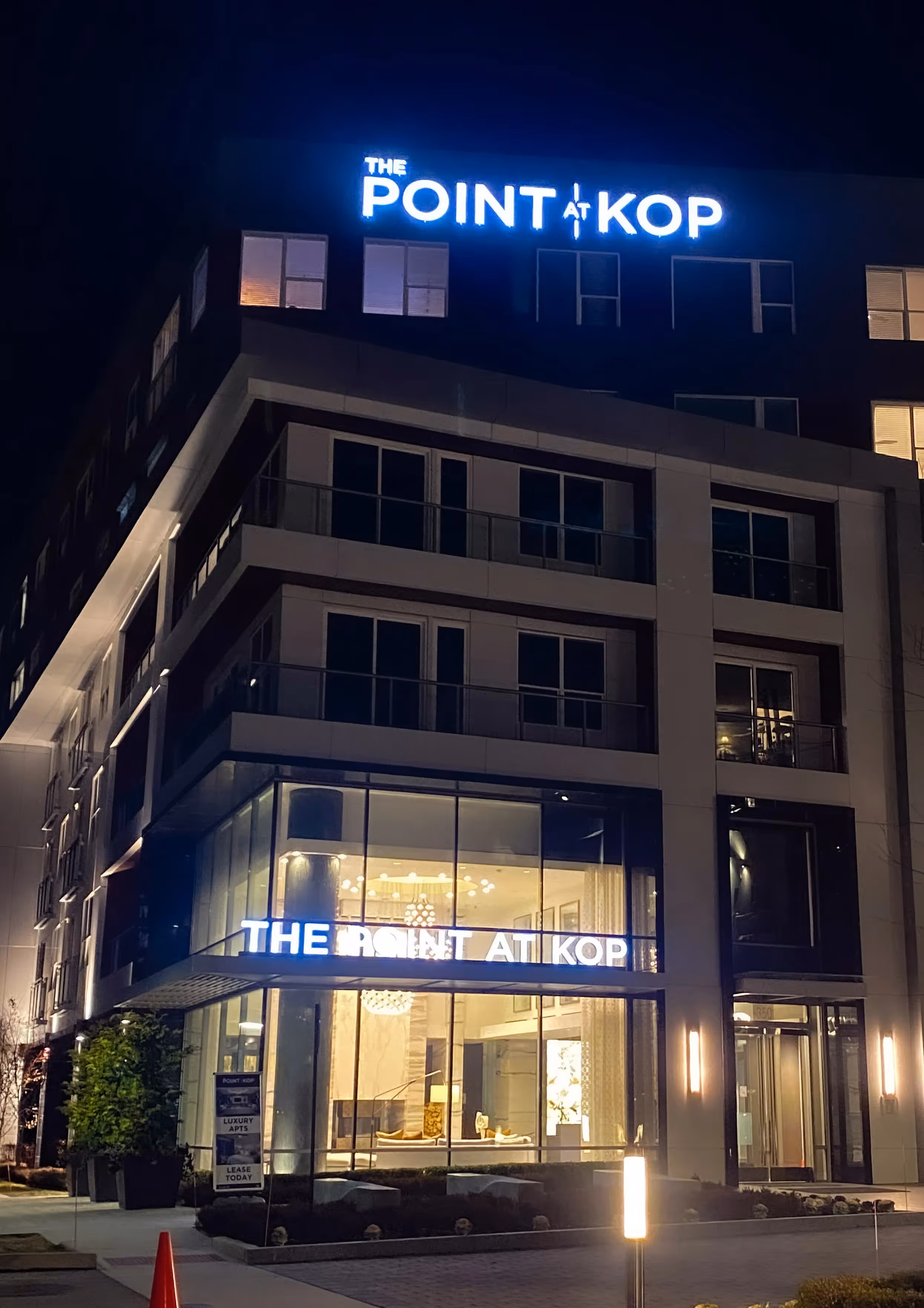Blue channel letters lit above an apartment building at night
