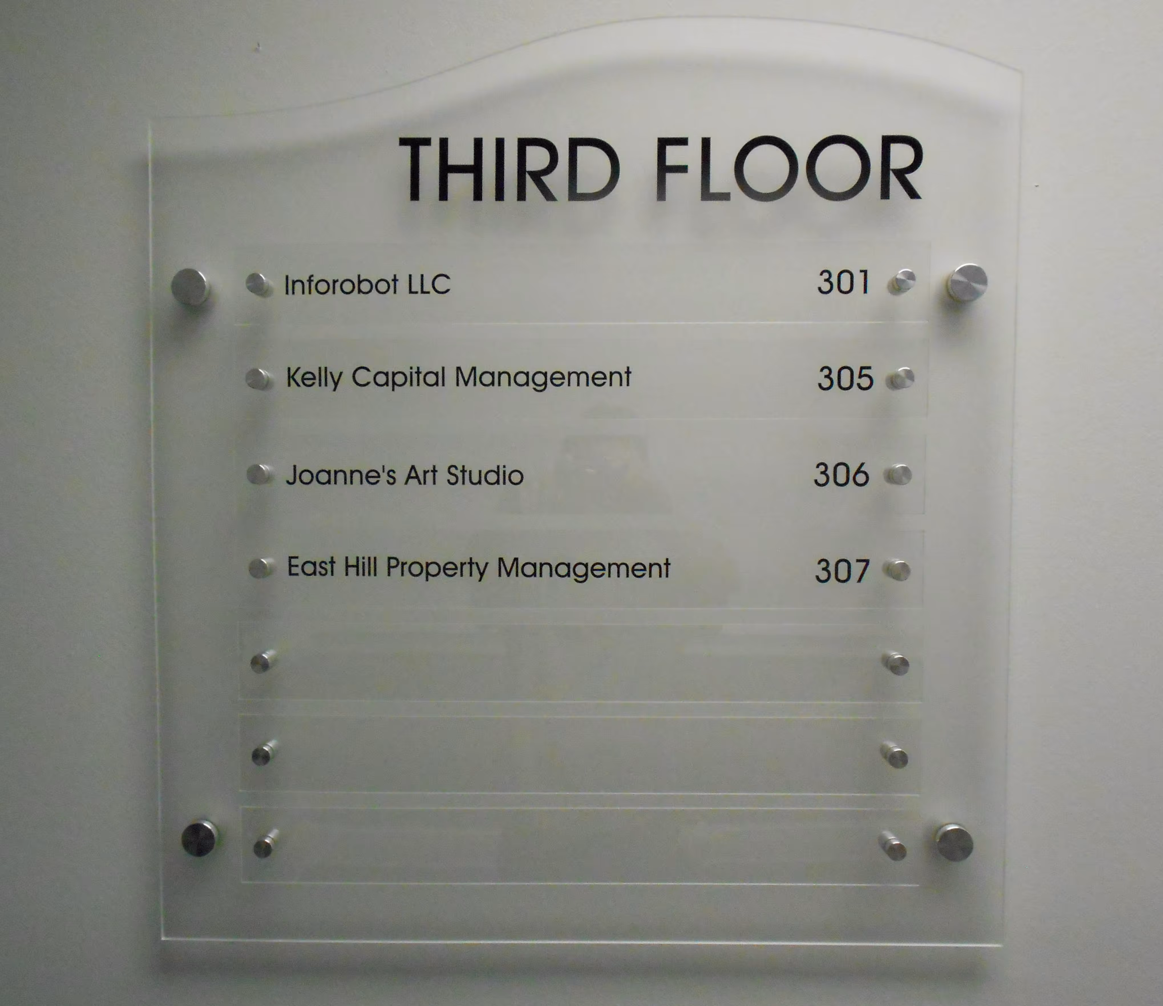 Clear acrylic building directory with black vinyl lettering mounted on standoffs