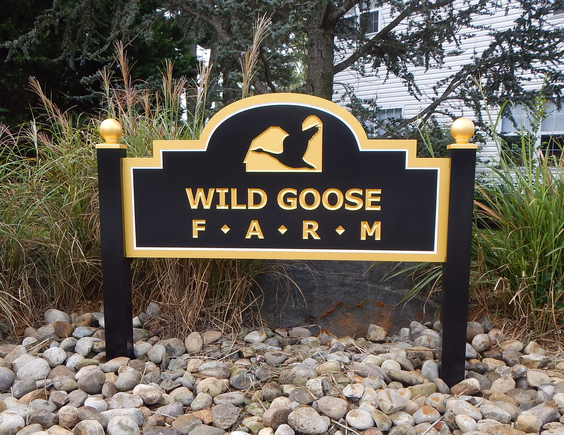 Black and gold carved HDU sign mounted between two black posts