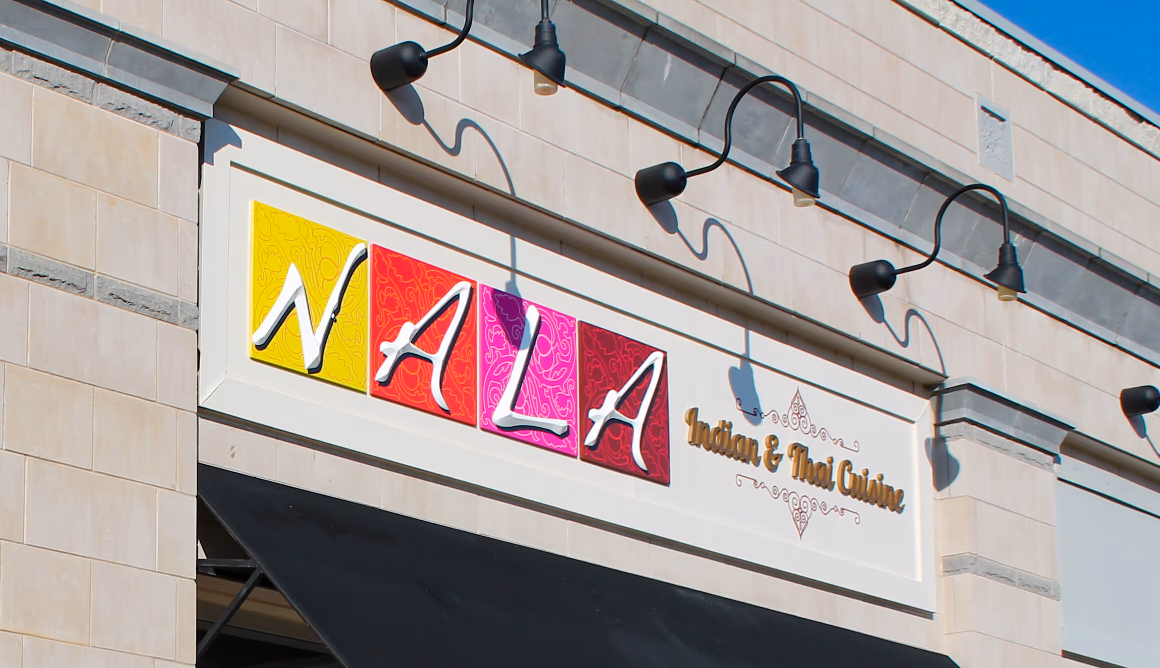 Colorful dimensional letters lit with gooseneck lamps