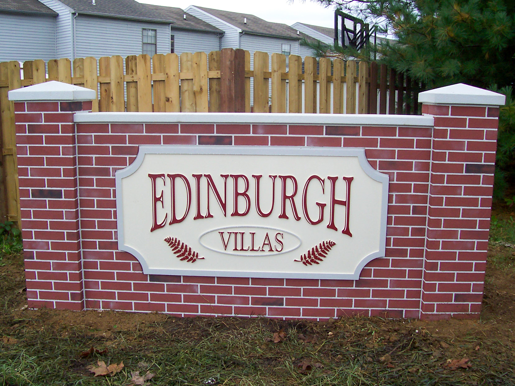 Carved HDU sign on a brick monument base