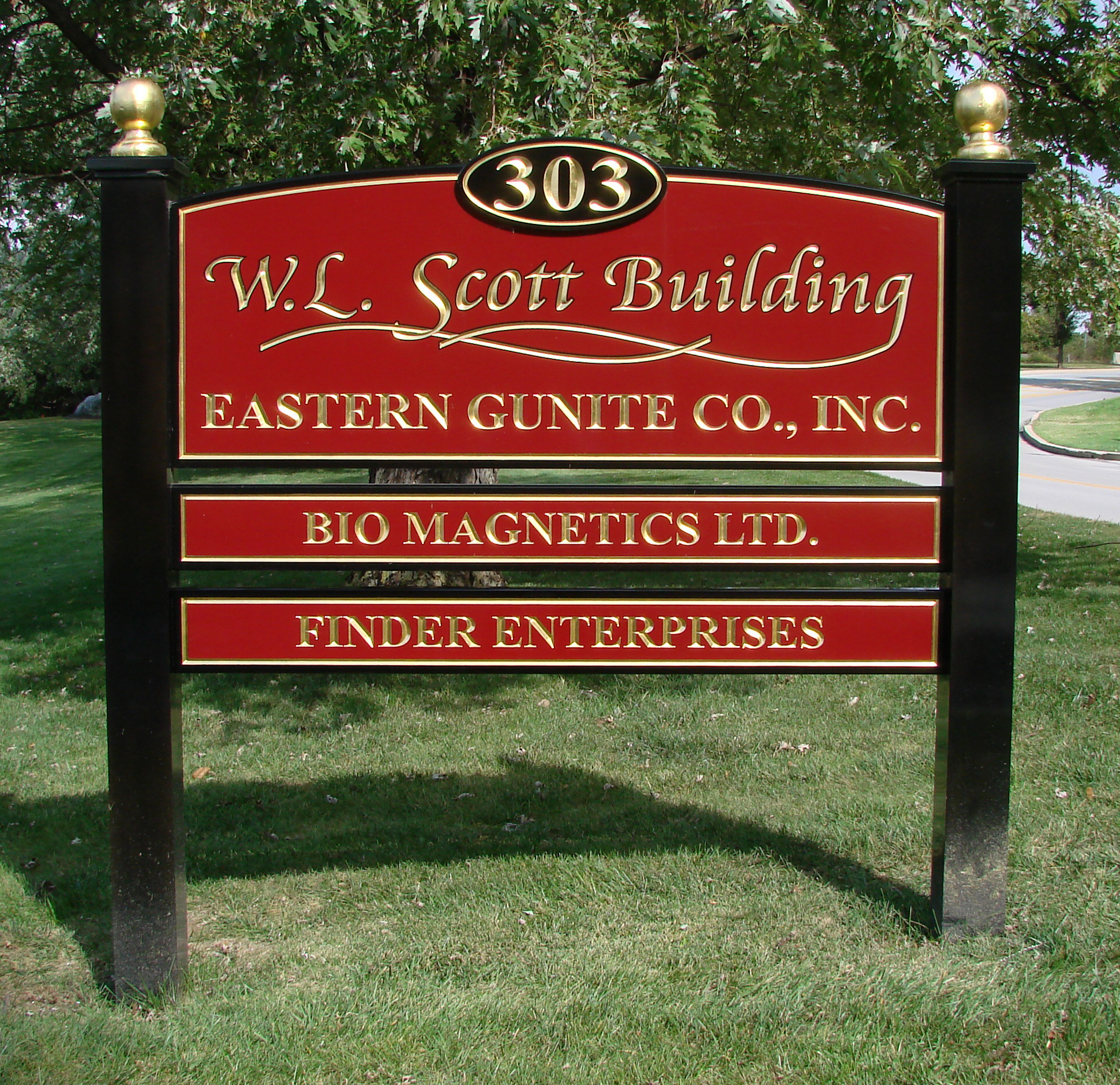 Red and black post and panel sign with large carved HDU face