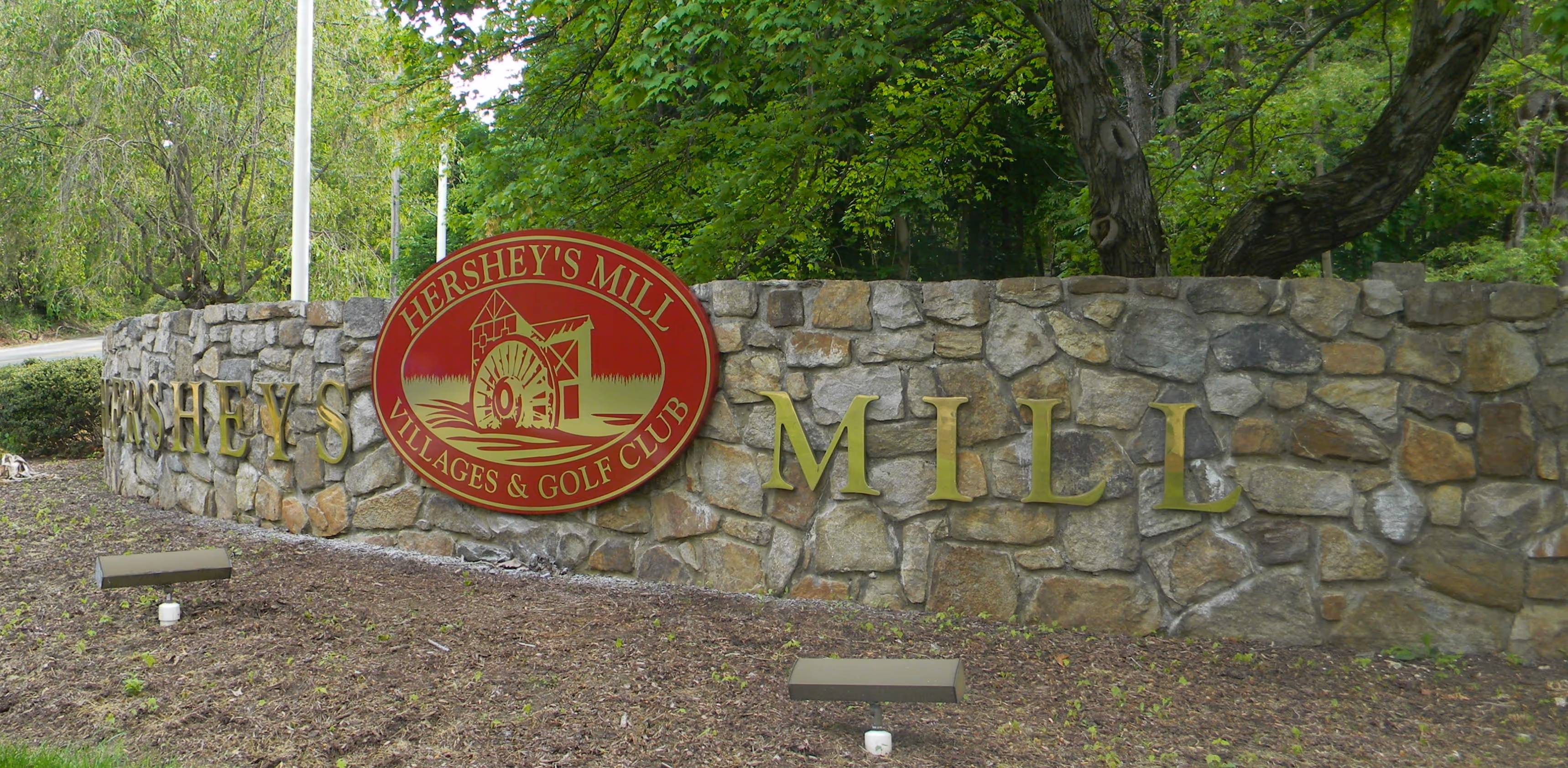 Carved HDU sign and metal dimensional letters at a neighborhood entrance