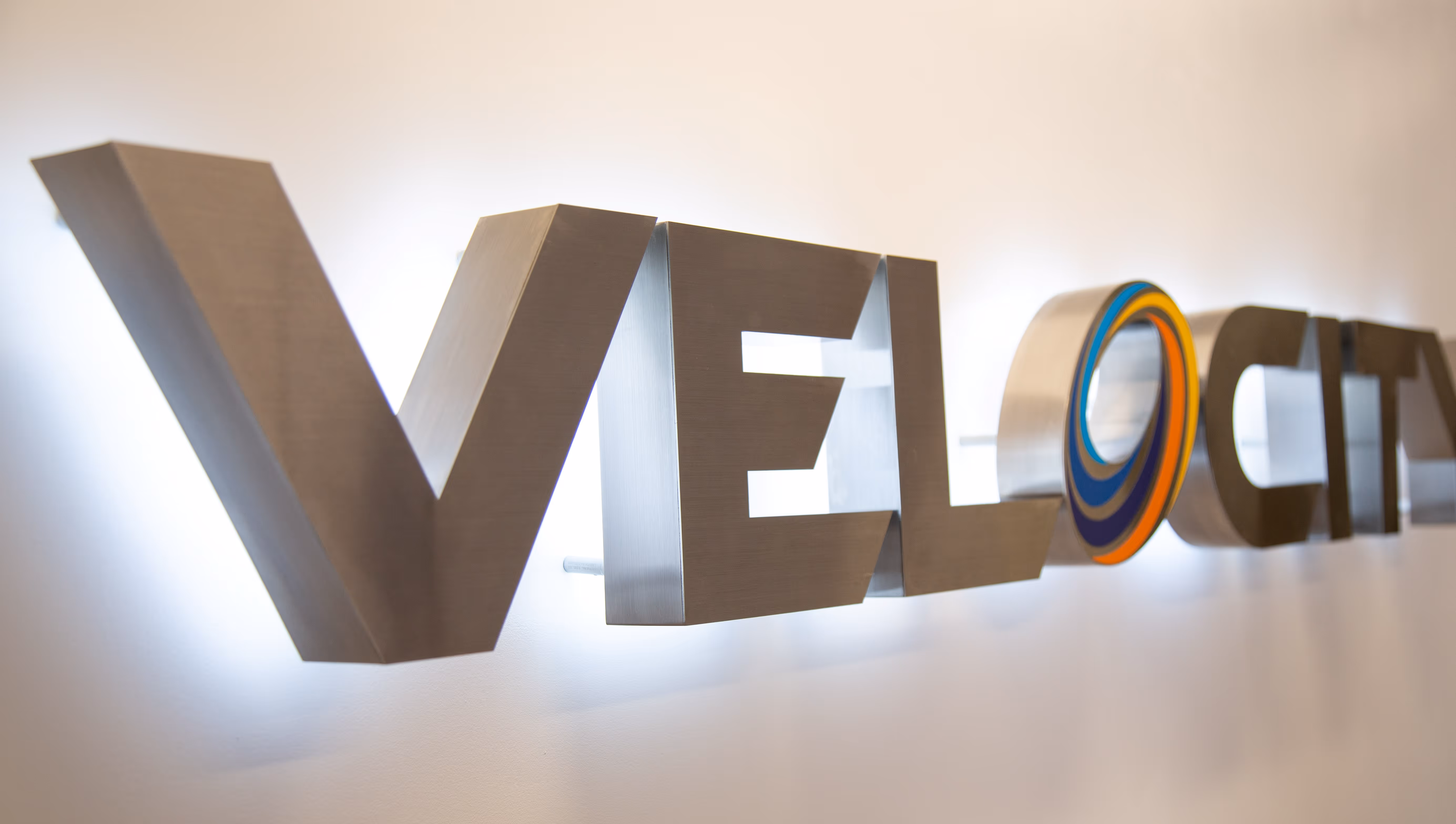 Halo-lit brushed aluminum channel letters with vinyl color on face