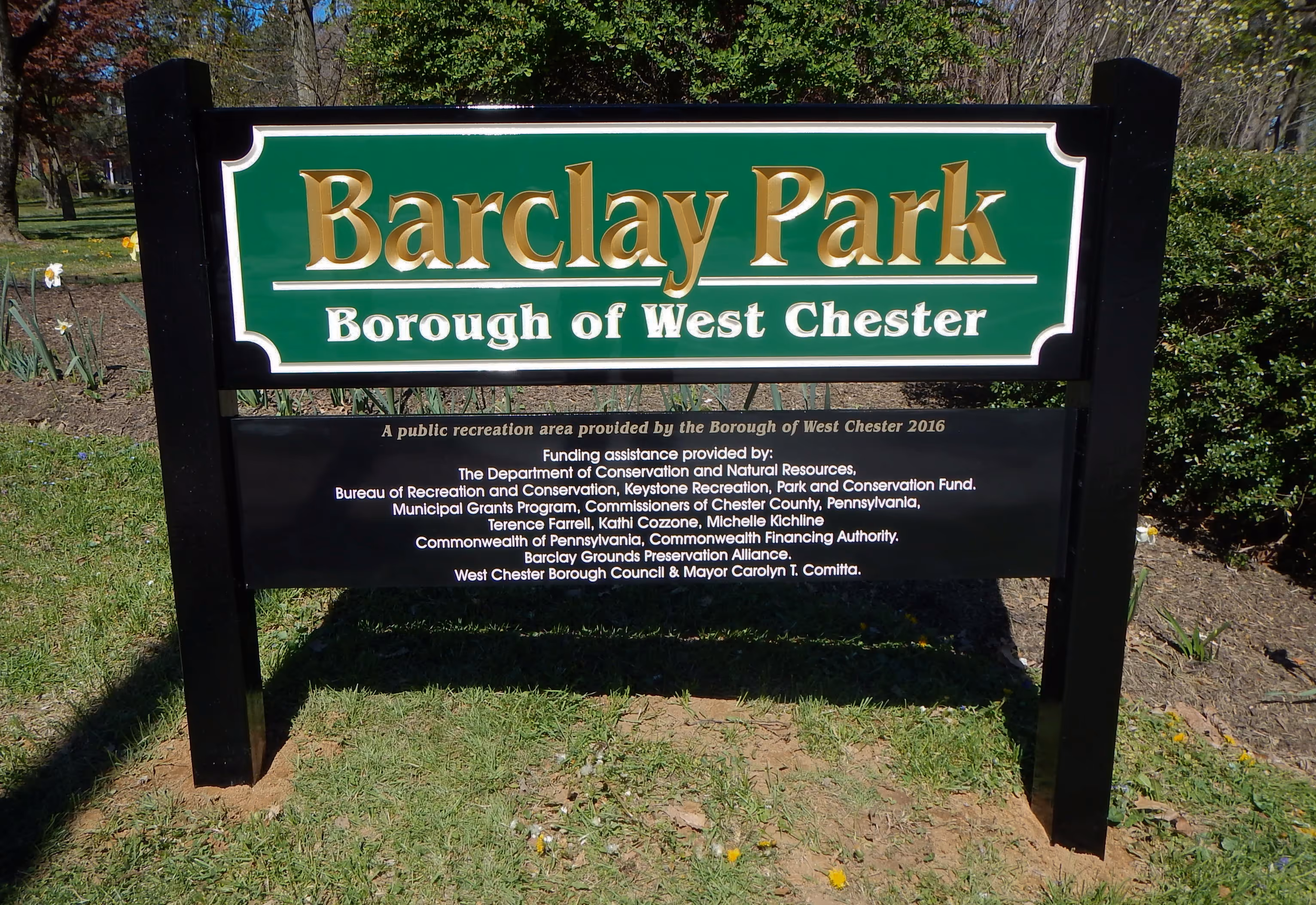 Carved HDU park sign hung between two place posts
