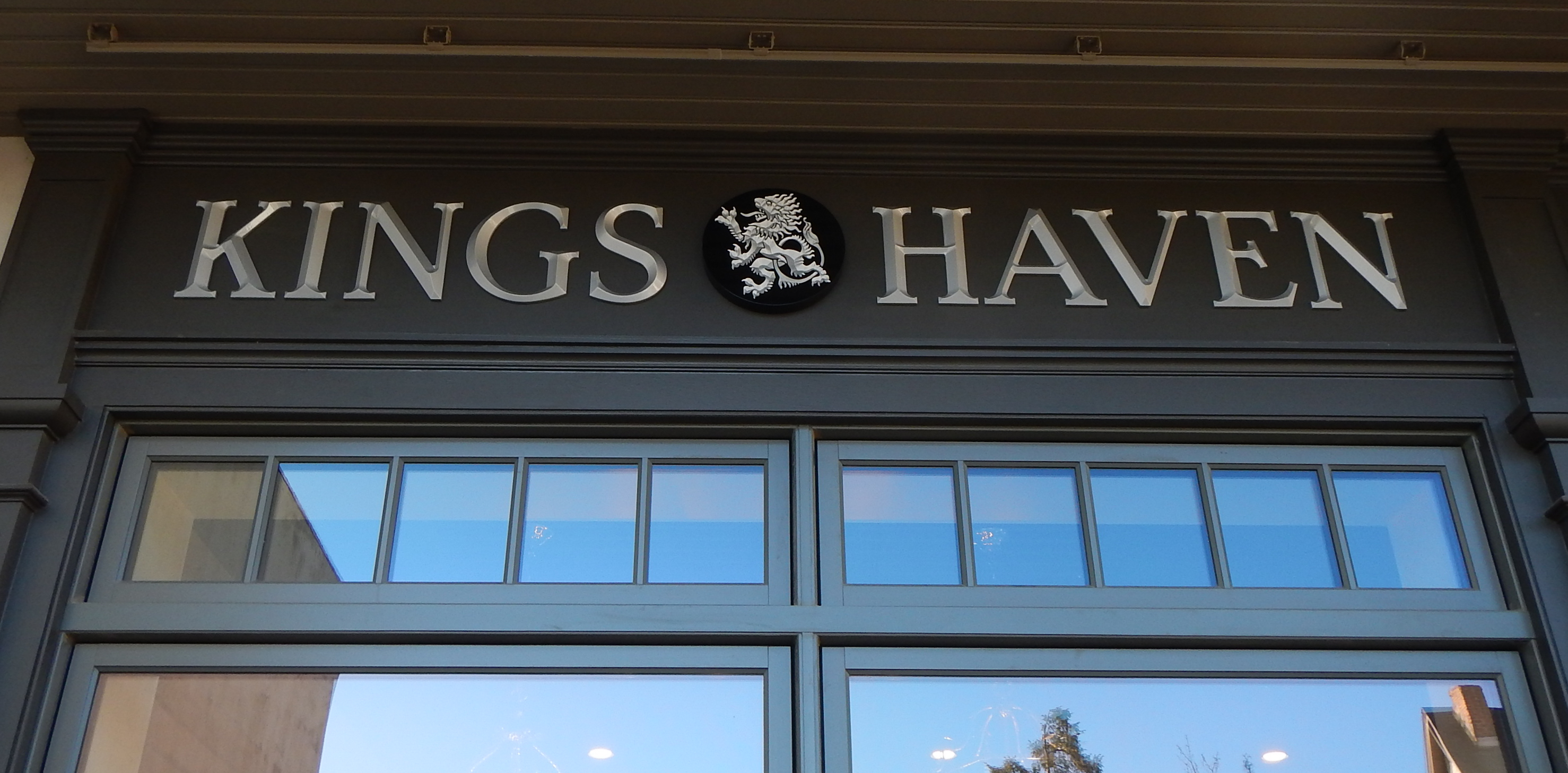 Silver dimensional letters and logo installed above an exterior window