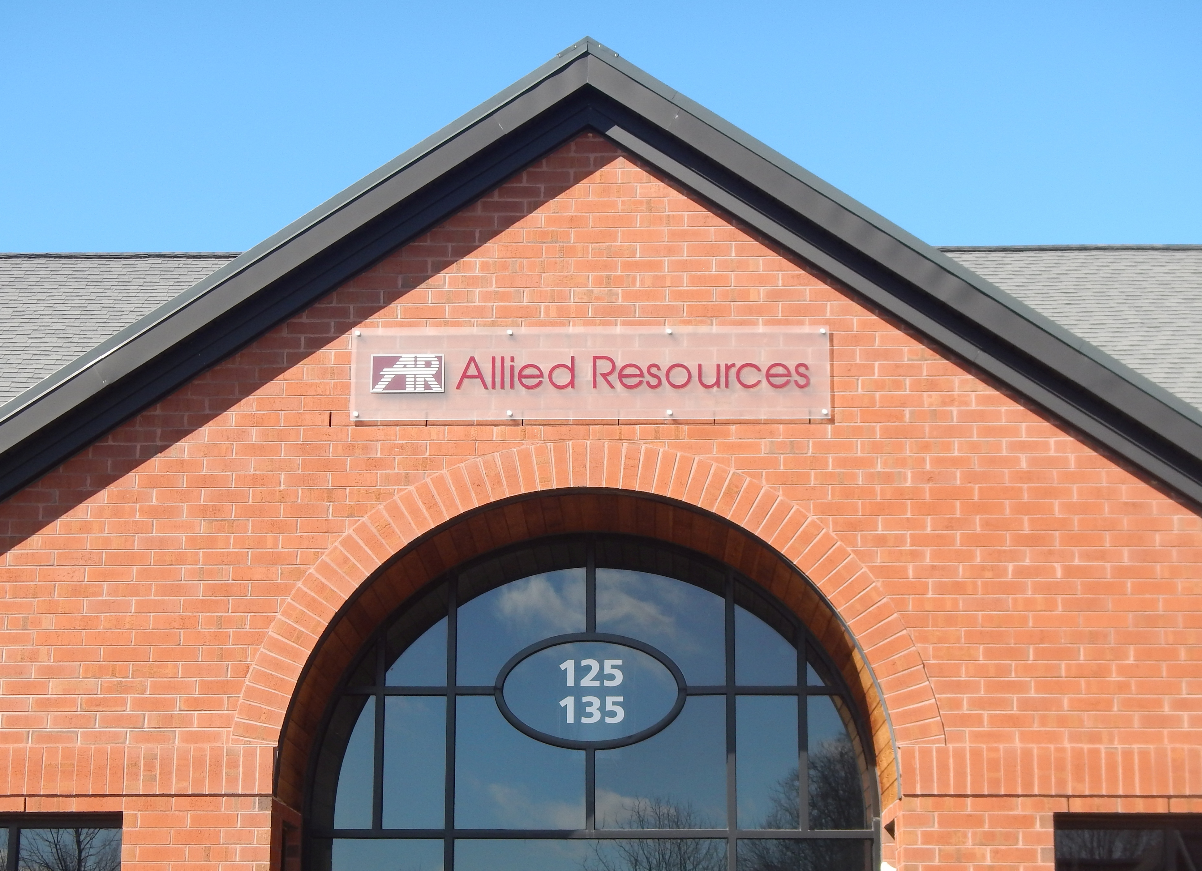 Frosted acrylic wall panel with red vinyl letters and logo