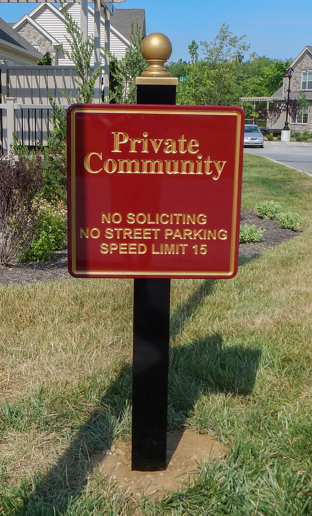 Carved HDU sign on a black post with gold finial