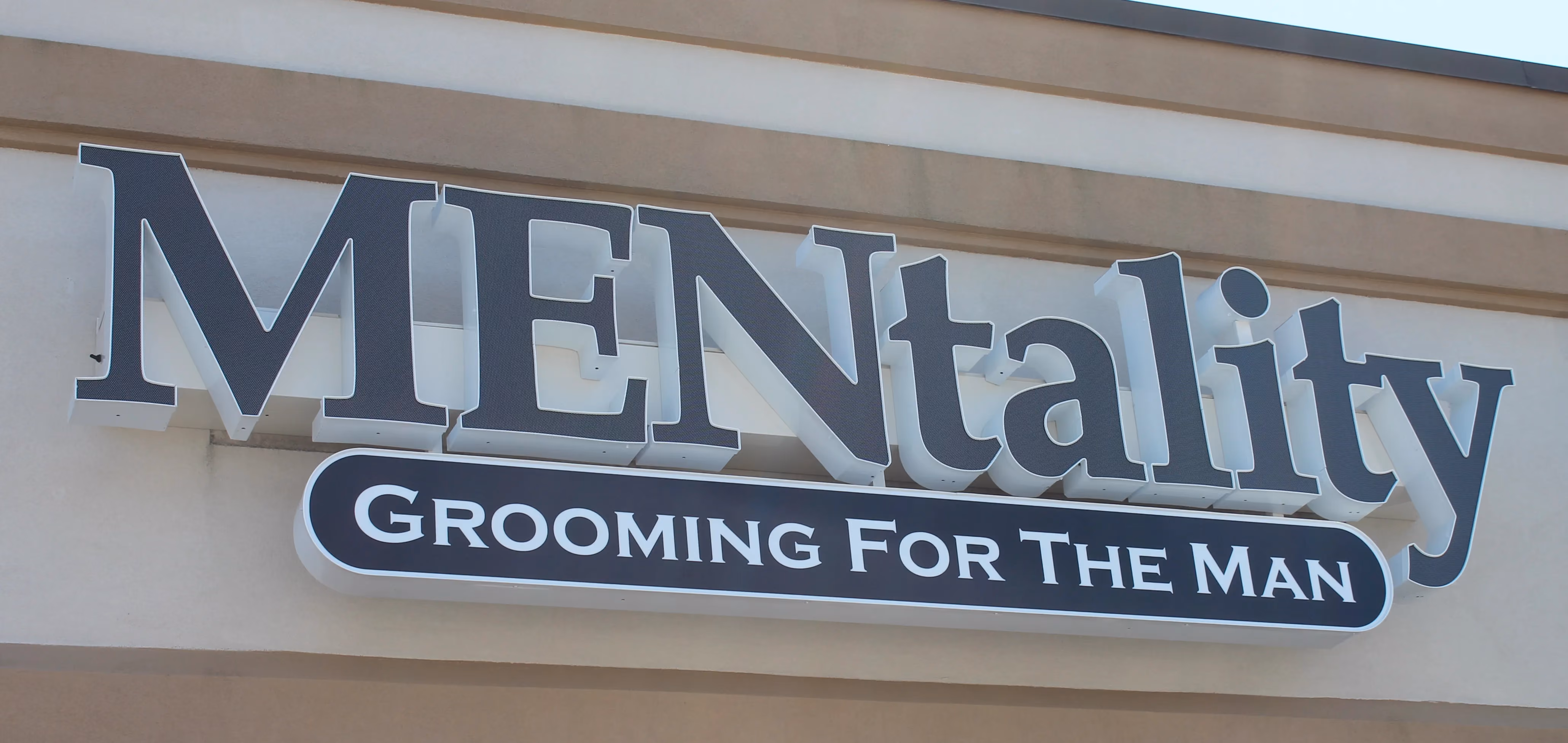 Navy blue channel letters mounted on a raceway