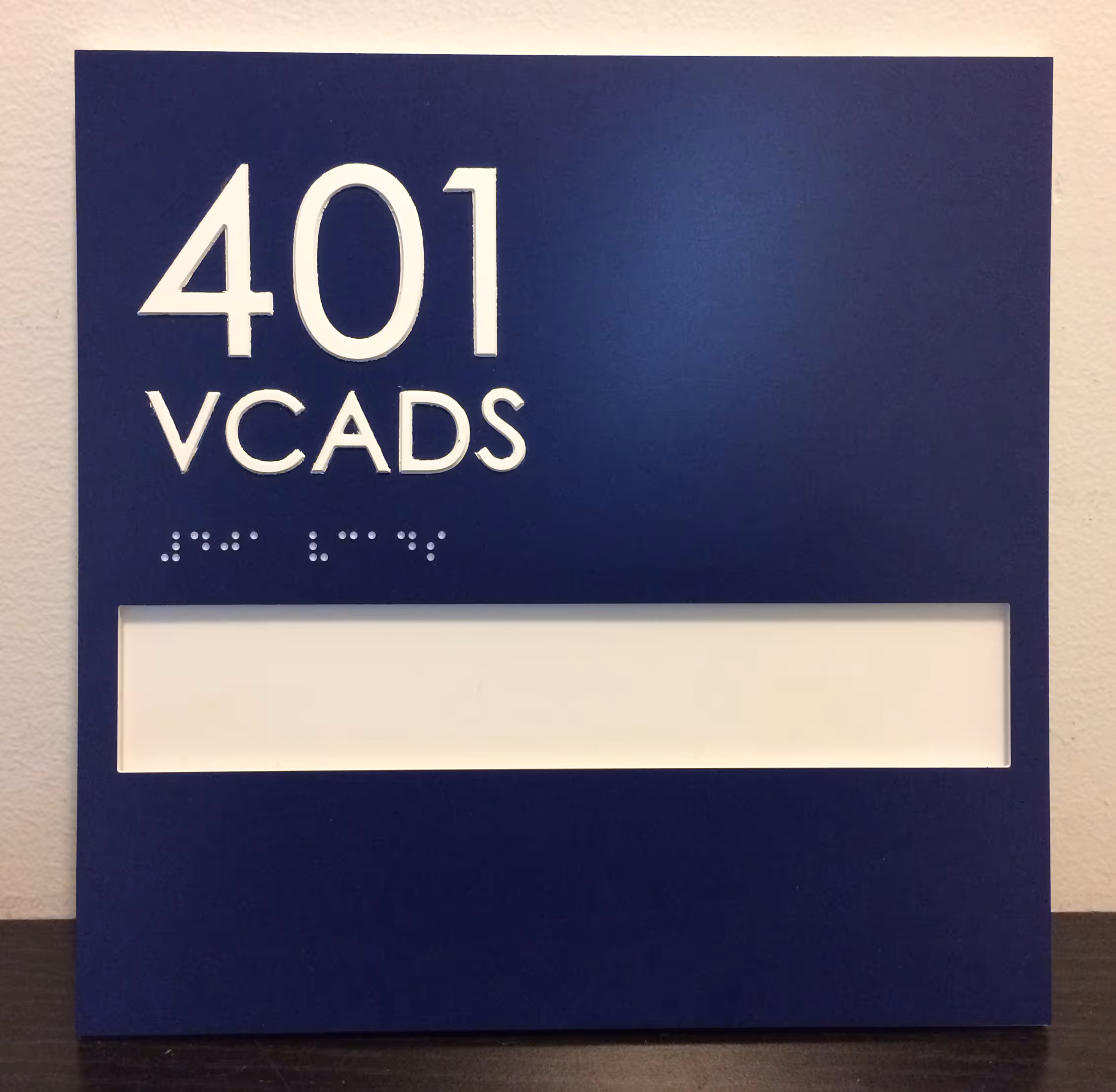Navy blue ADA room sign with window