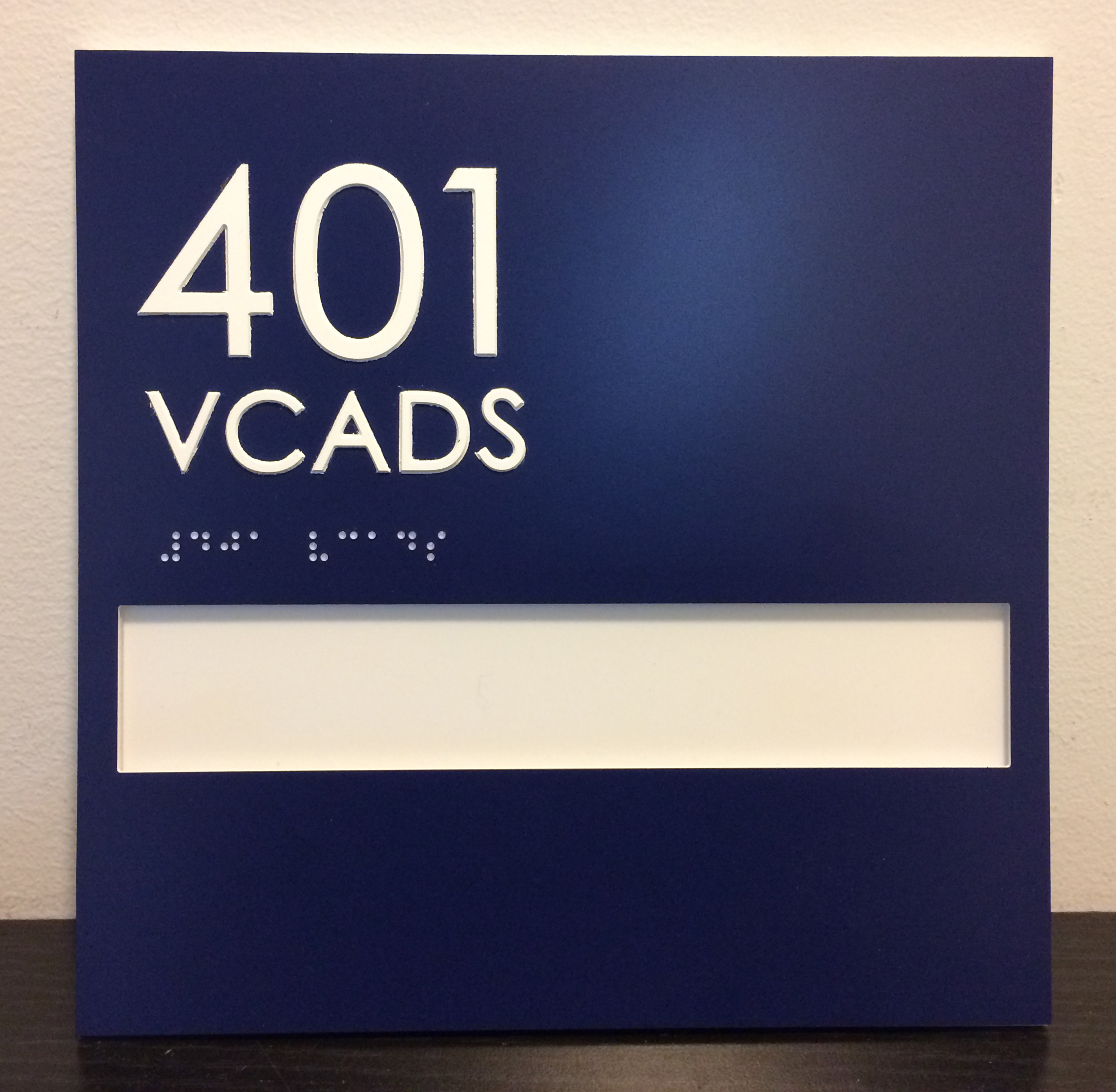 Navy blue ADA room sign with window