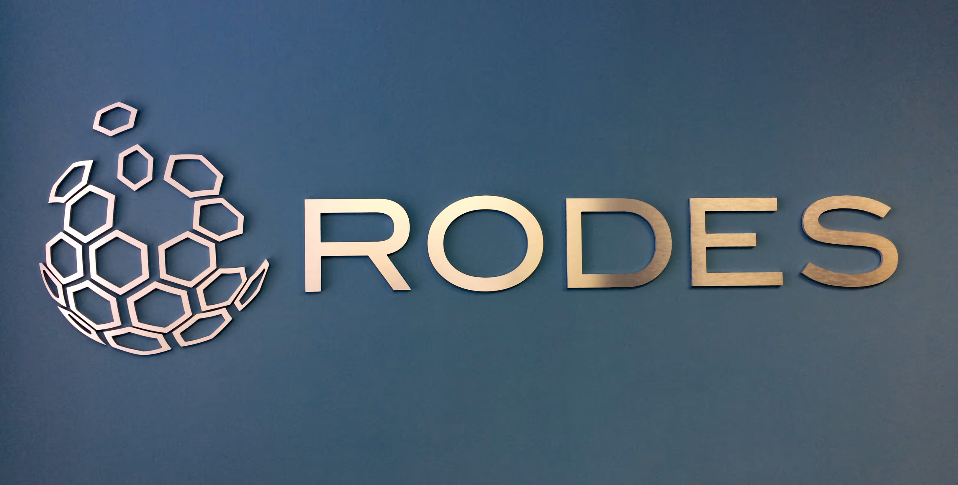 Complex, dimensional metal logo mounted on a wall