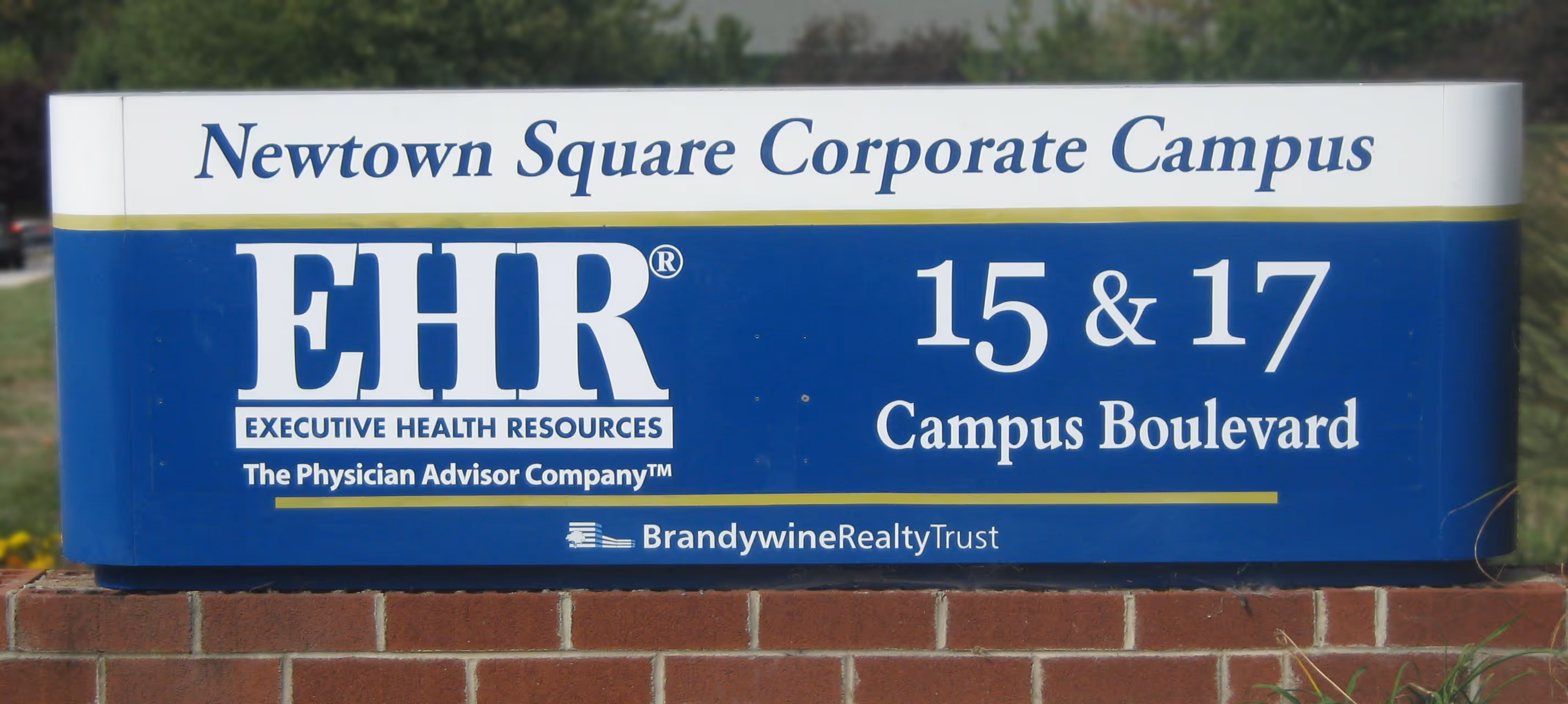 Multi-colored aluminum monument sign on a brick base