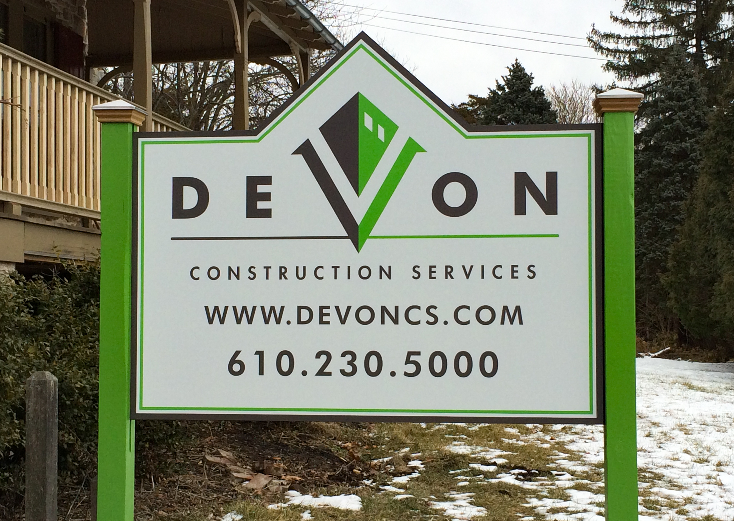 Post and panel sign mounted between two fluorescent green posts