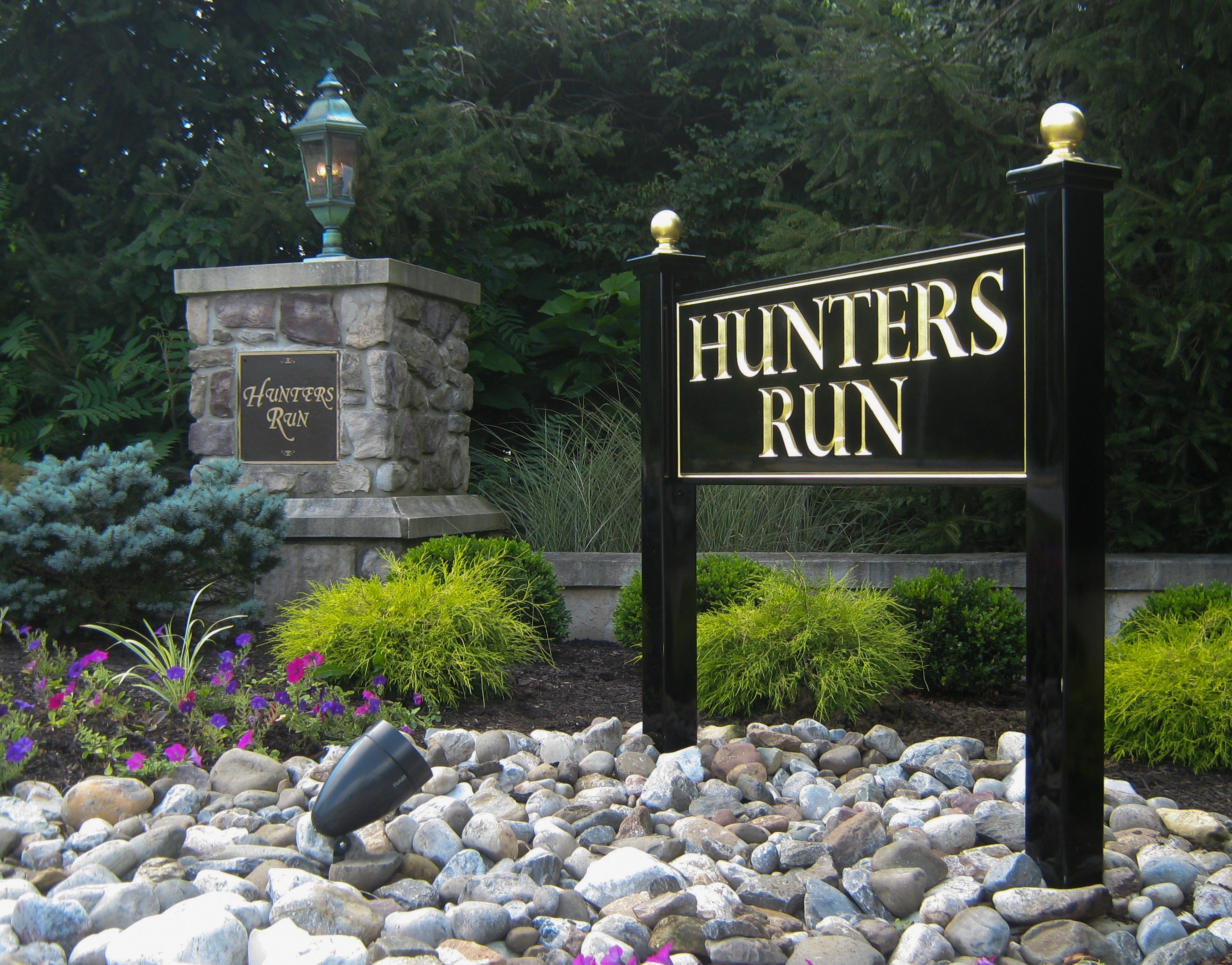 Carved HDU sign on black posts with gold finials