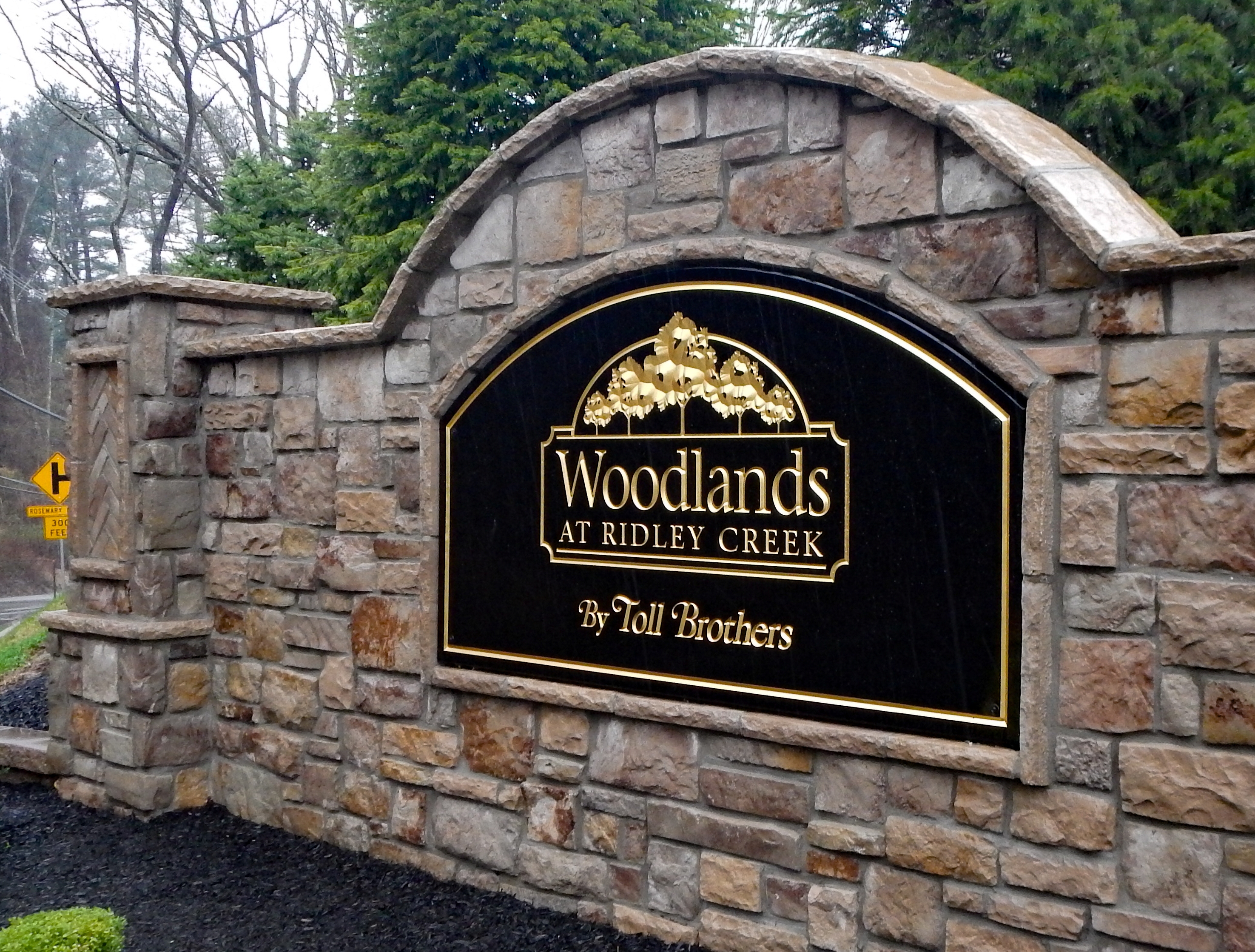 Carved black HDU sign framed within a large stone wall