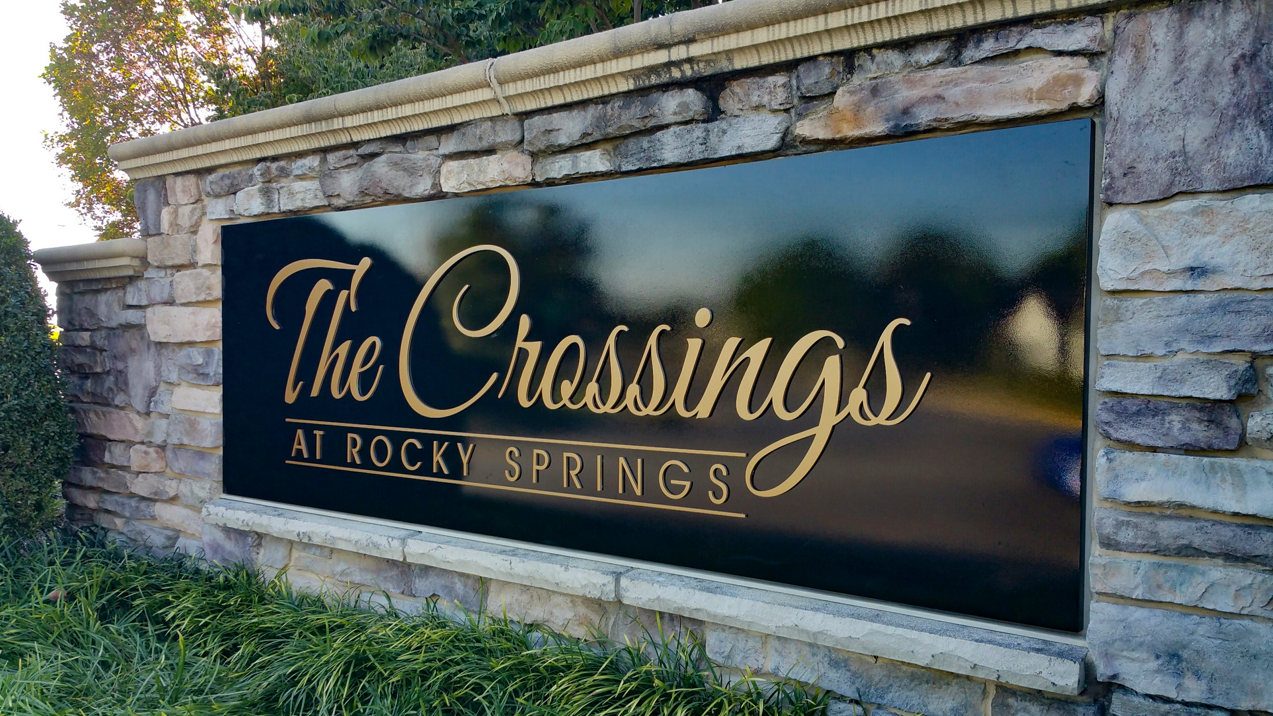 Painted dimensional letters embedded into a large stone monument base