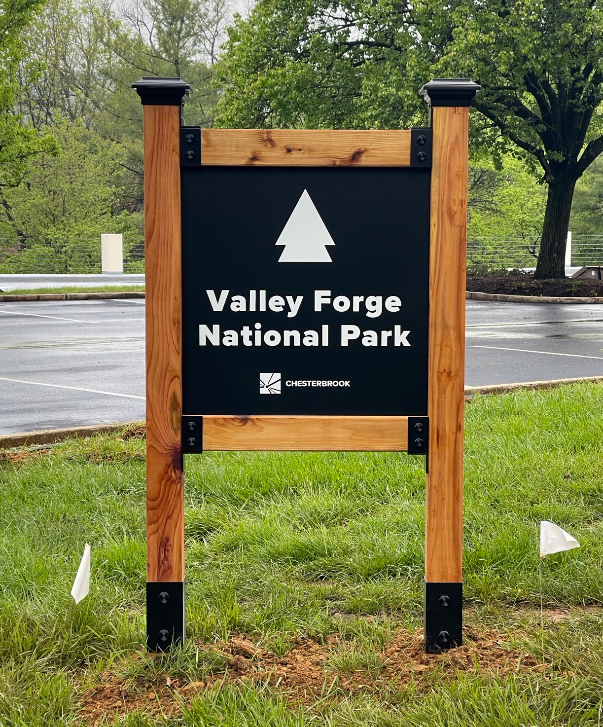 Post and panel monument sign made from stained wood and heavy metal hardware