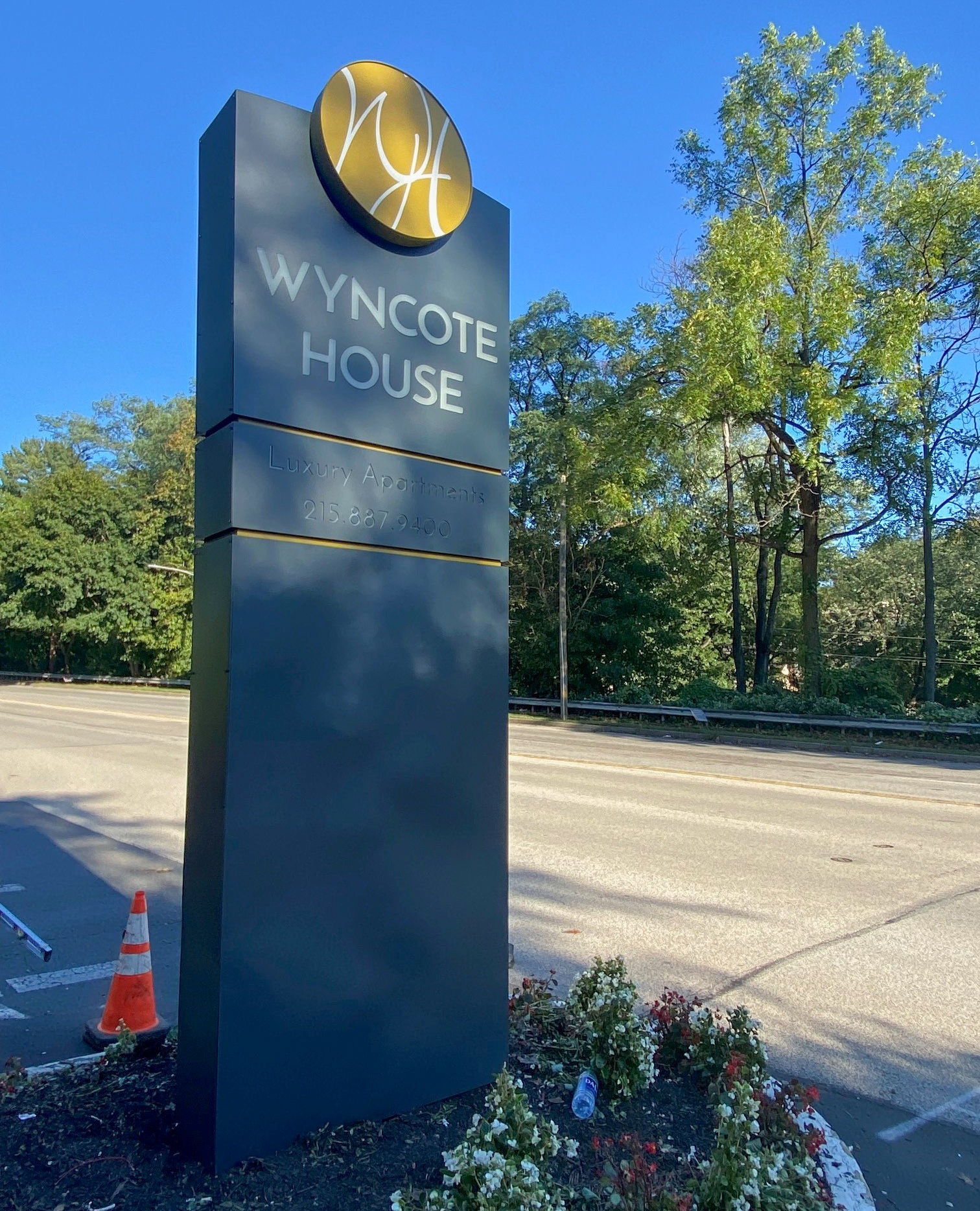 Large aluminum pylon sign at the entrance to an apartment complex