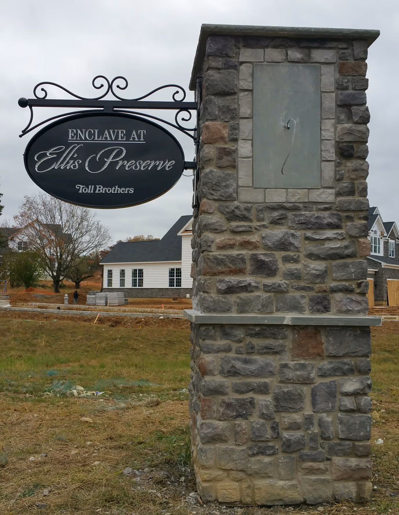 Large stone pillar with an oval carved HDU sign hanging from a scroll bar